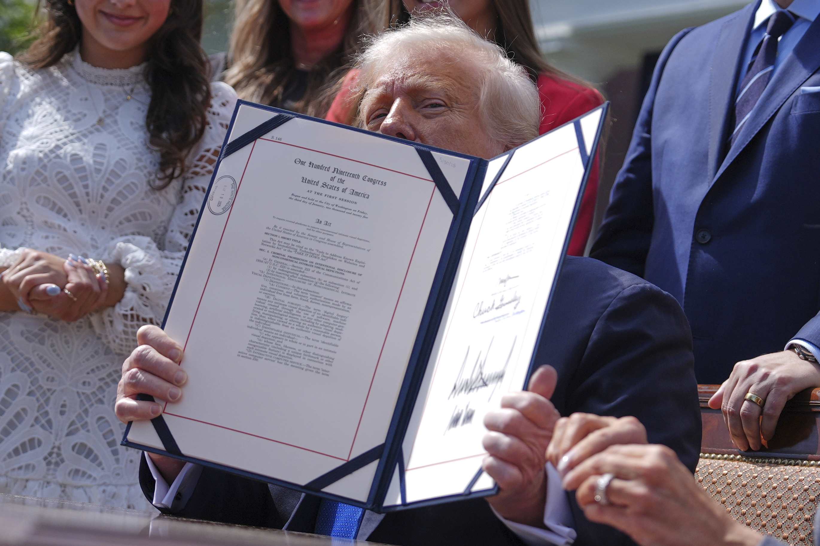 Donald Trump holds up an executive order