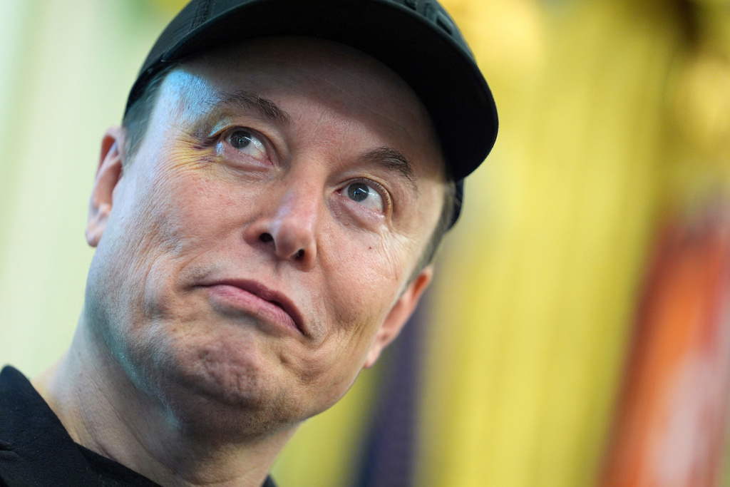Elon Musk listens during a news conference