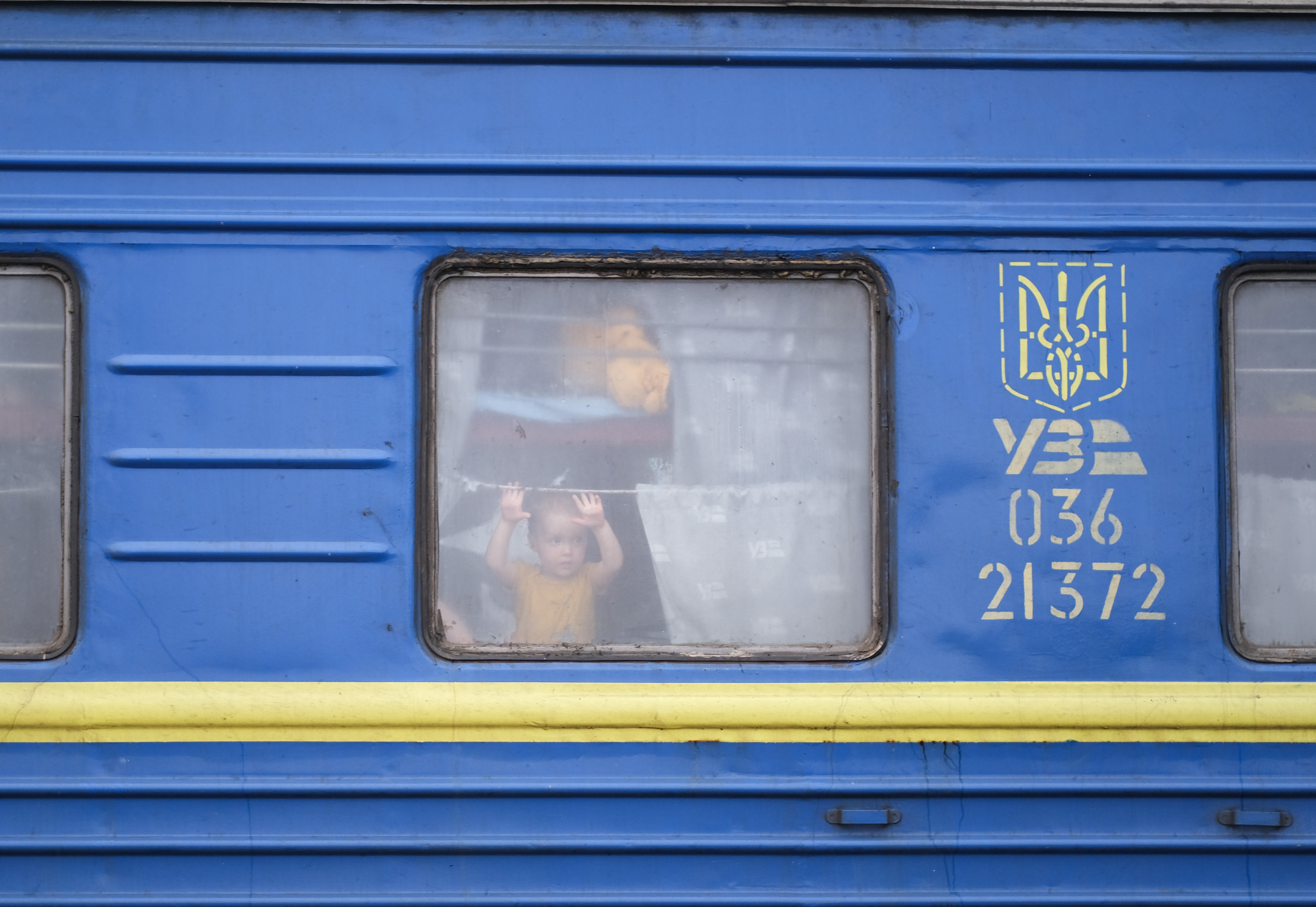 A child looks out of a train headed to western Ukraine during the first weeks of Russia’s full-scale invasion of Ukraine