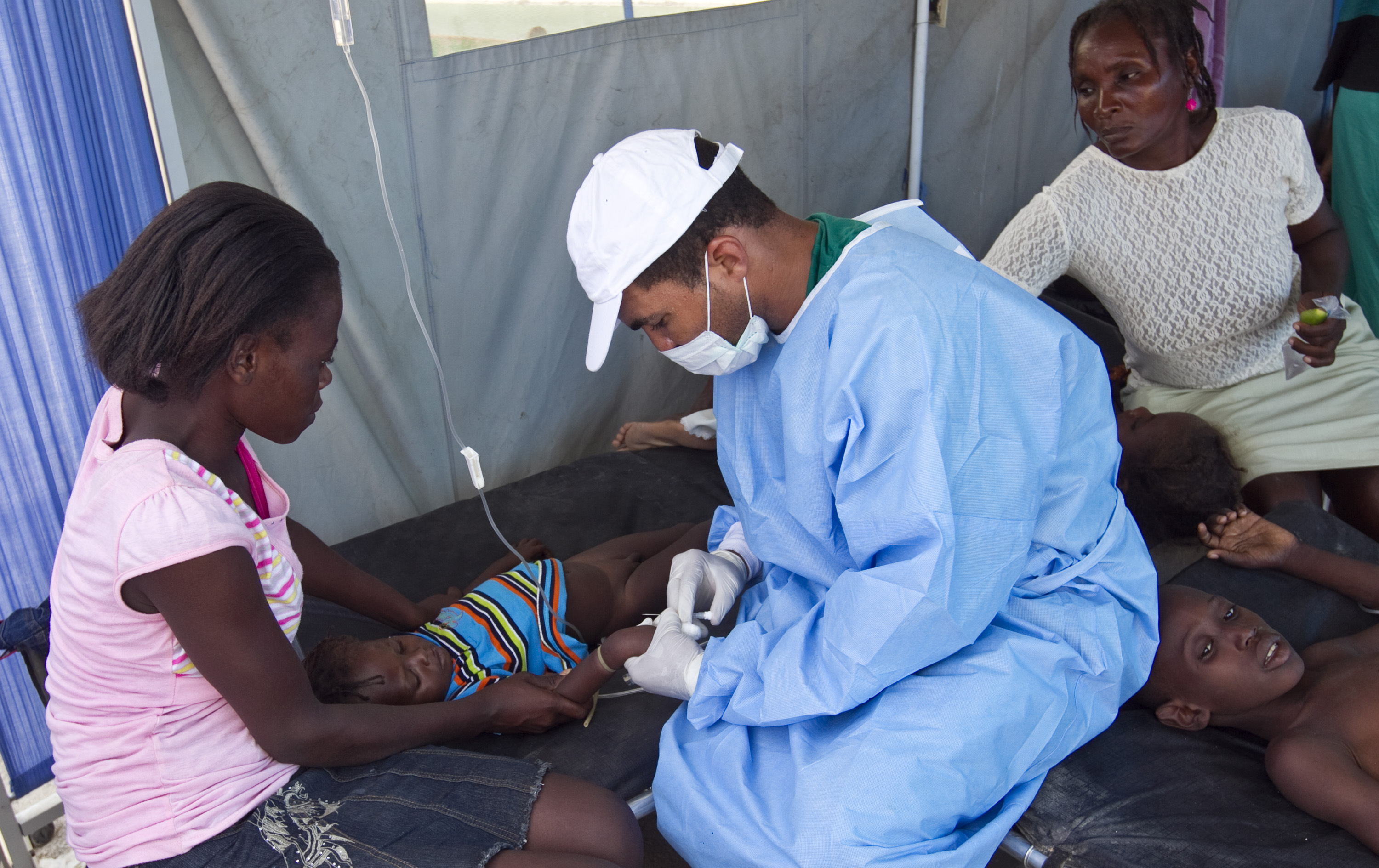 A cholera patient is treated with an IV solution administered by a Cuban doctor at a hospital in L'Estere, Haiti, on October 26, 2010