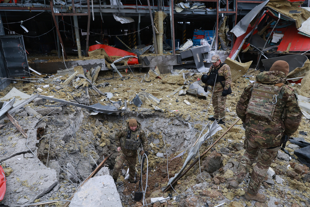 Sappers examine the site of a Russian missile strike which hit a post office storehouse in Zaporizhzhia, Ukraine, on 17 March, 2026