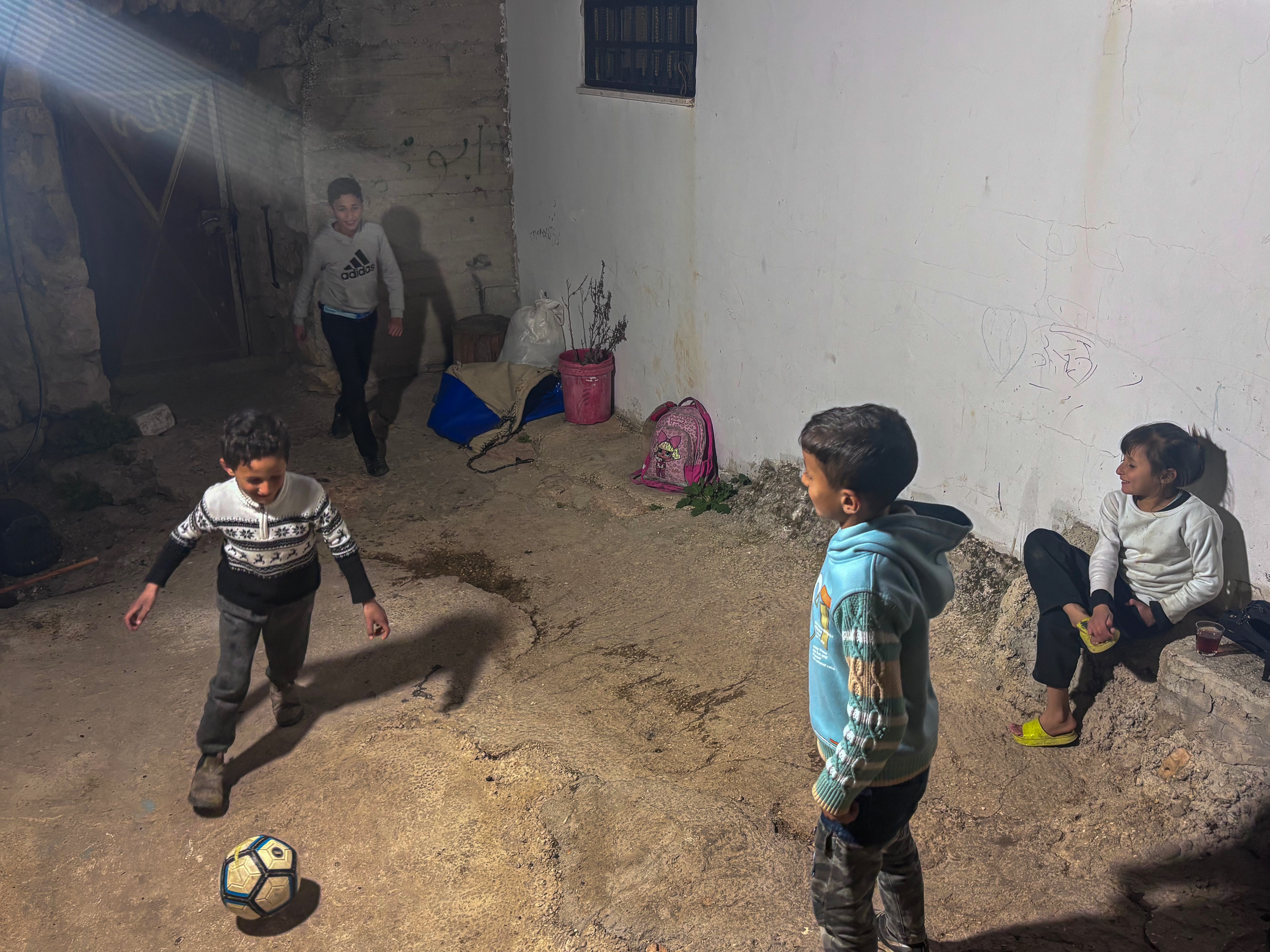 Musa (L) and his cousins play football inside the family compound [Al Jazeera]