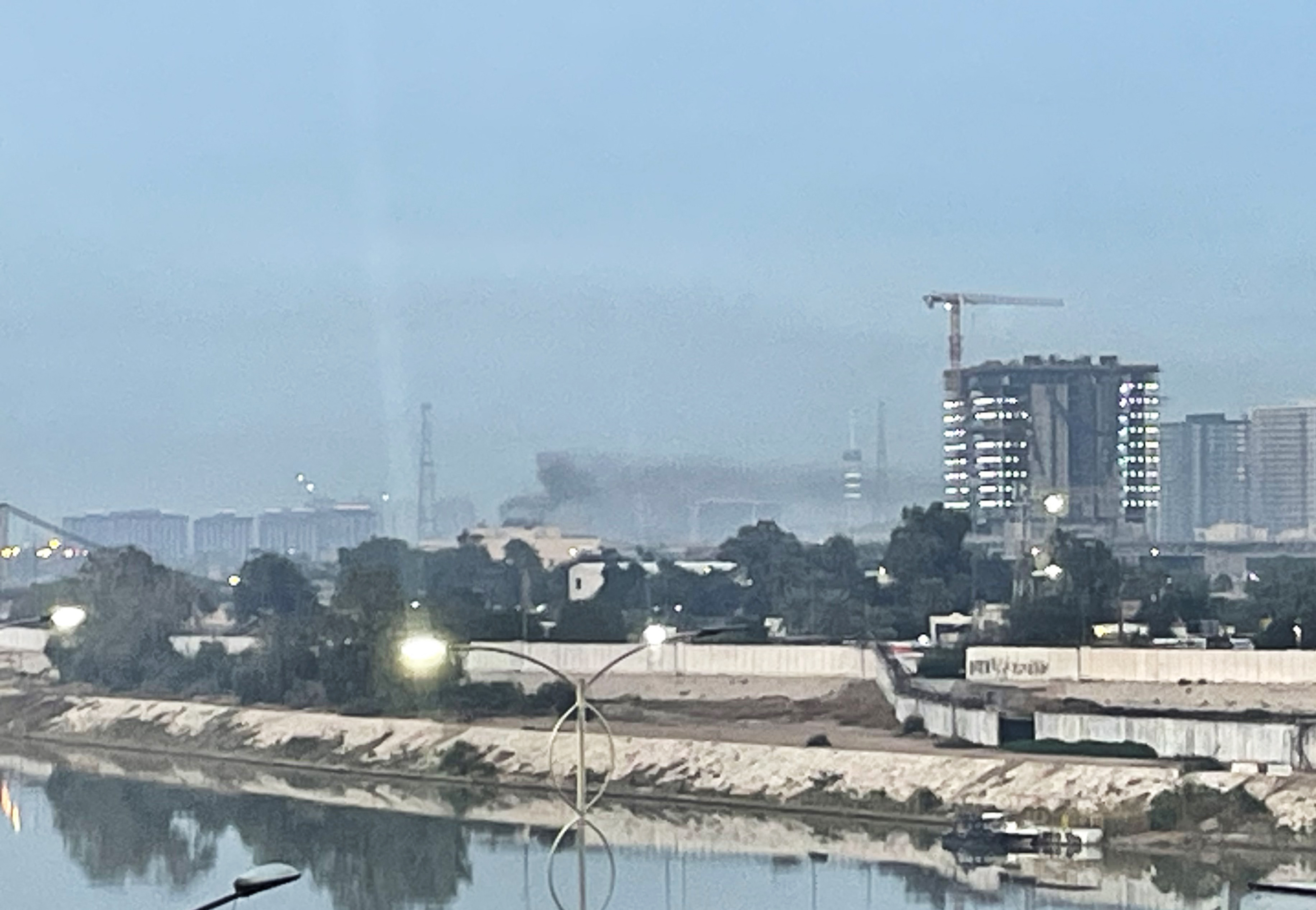 Smoke rises from a building in the distance.