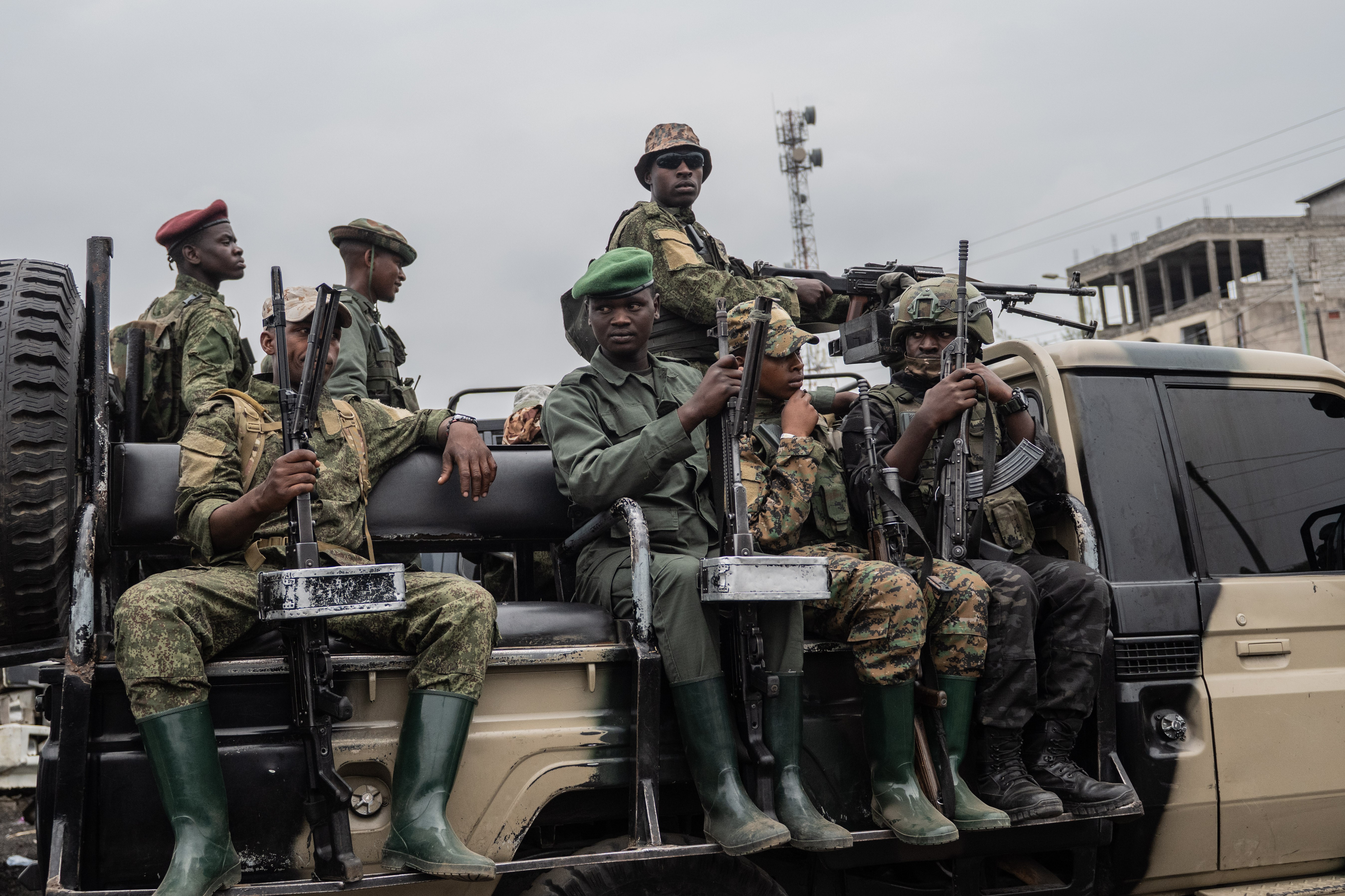 Armed security personnel keep watch during a collective memorial service organized by the Alliance Fleuve Congo (AFC) and the M23 armed group