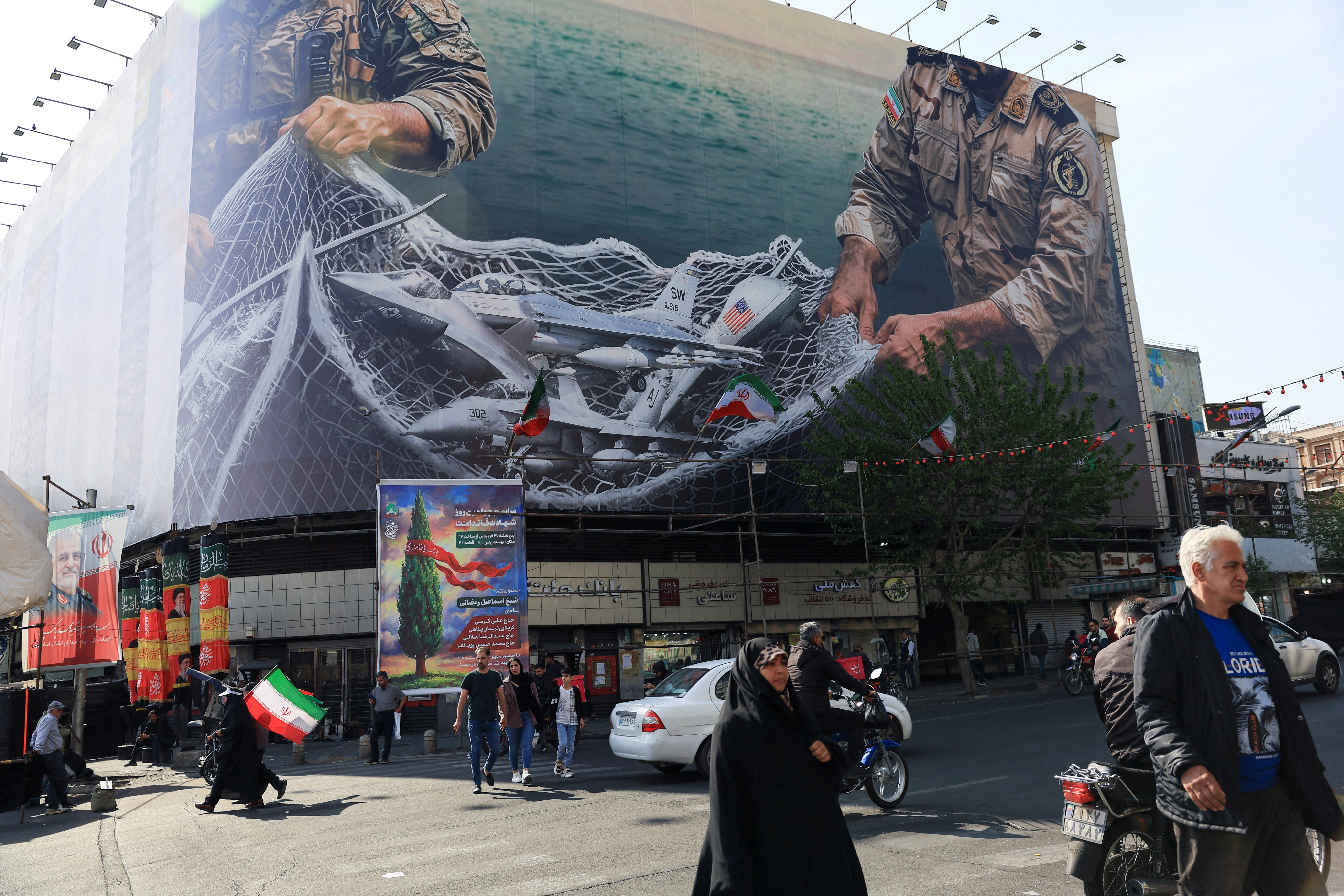 People walk near an anti-U.S. billboard on a building in Tehran, Iran, April 16, 2026. REUTERS/Thaier Al-Sudani Foreign media in Iran operate under guidelines set by the Ministry of Culture and Islamic Guidance, which regulates press activity and permissions. TPX IMAGES OF THE DAY