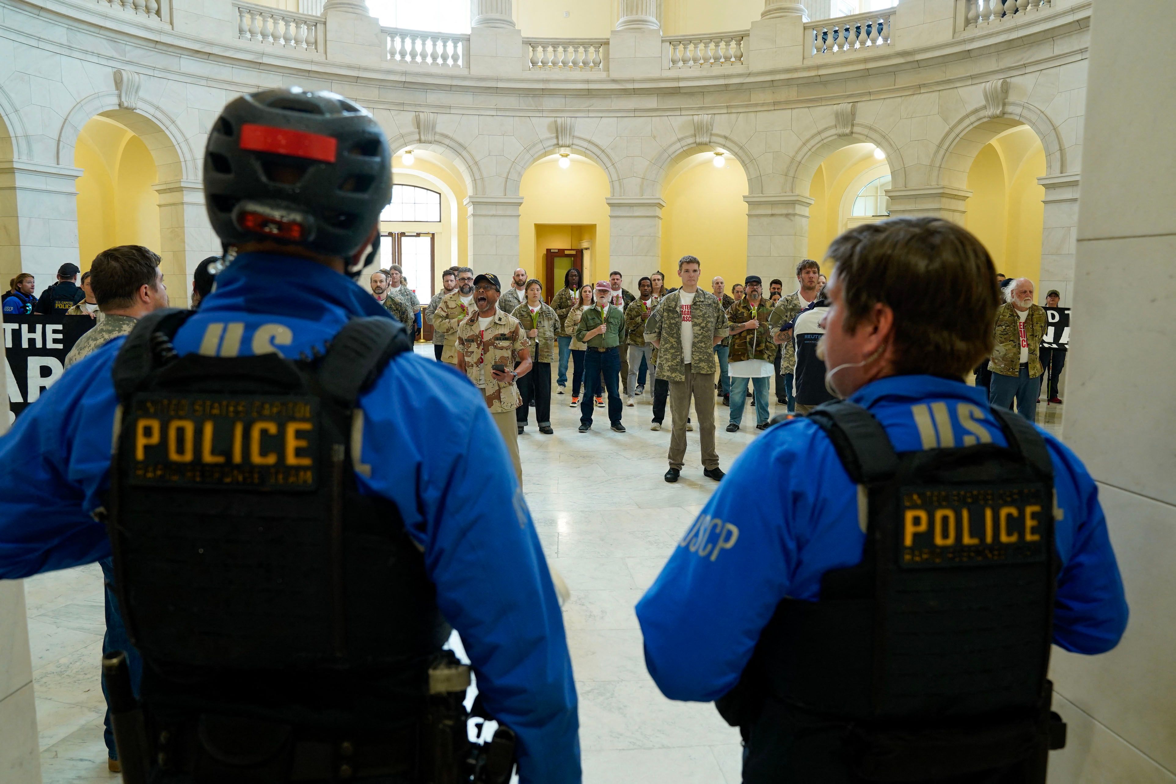 WASHINGTON, DC - APRIL 20: U.S. Capitol Police officers look on as veterans, military family members, and supporters occupy the Cannon House Office Building on Capitol Hill calling upon the Trump administration to end the war on Iran on April 20, 2026 in Washington, DC. Leigh Vogel/Getty Images for About Face: Veterans Against The War/AFP (Photo by Leigh Vogel / GETTY IMAGES NORTH AMERICA / Getty Images via AFP)