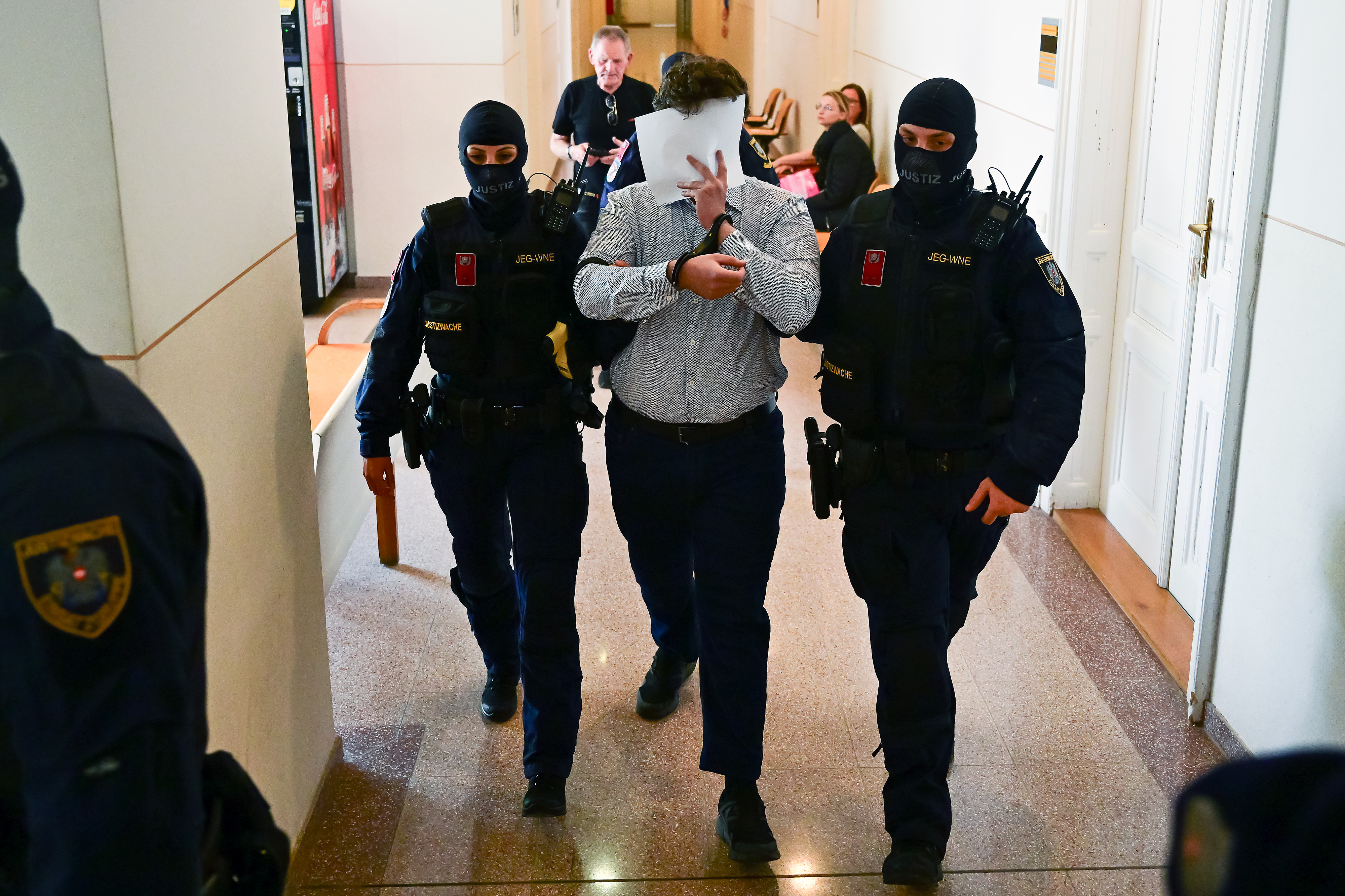 WIENER NEUSTADT, AUSTRIA - APRIL 28: Defendant Beran A. is lead to the hearing room after a break on the first day of the Taylor Swift concert plot trial at Regional Court Wiener Neustadt on April 28, 2026 in Wiener Neustadt, Austria. Two young men are charged with terrorism and other offences over plotting three terrorist attacks. One of them planned to attack a Taylor Swift concert in Vienna in August 2024. Three dates of Taylor Swift's "Eras" tour were canceled in the summer of 2024 after authorities were warned of a plot. (Photo by Christian Bruna/Getty Images)