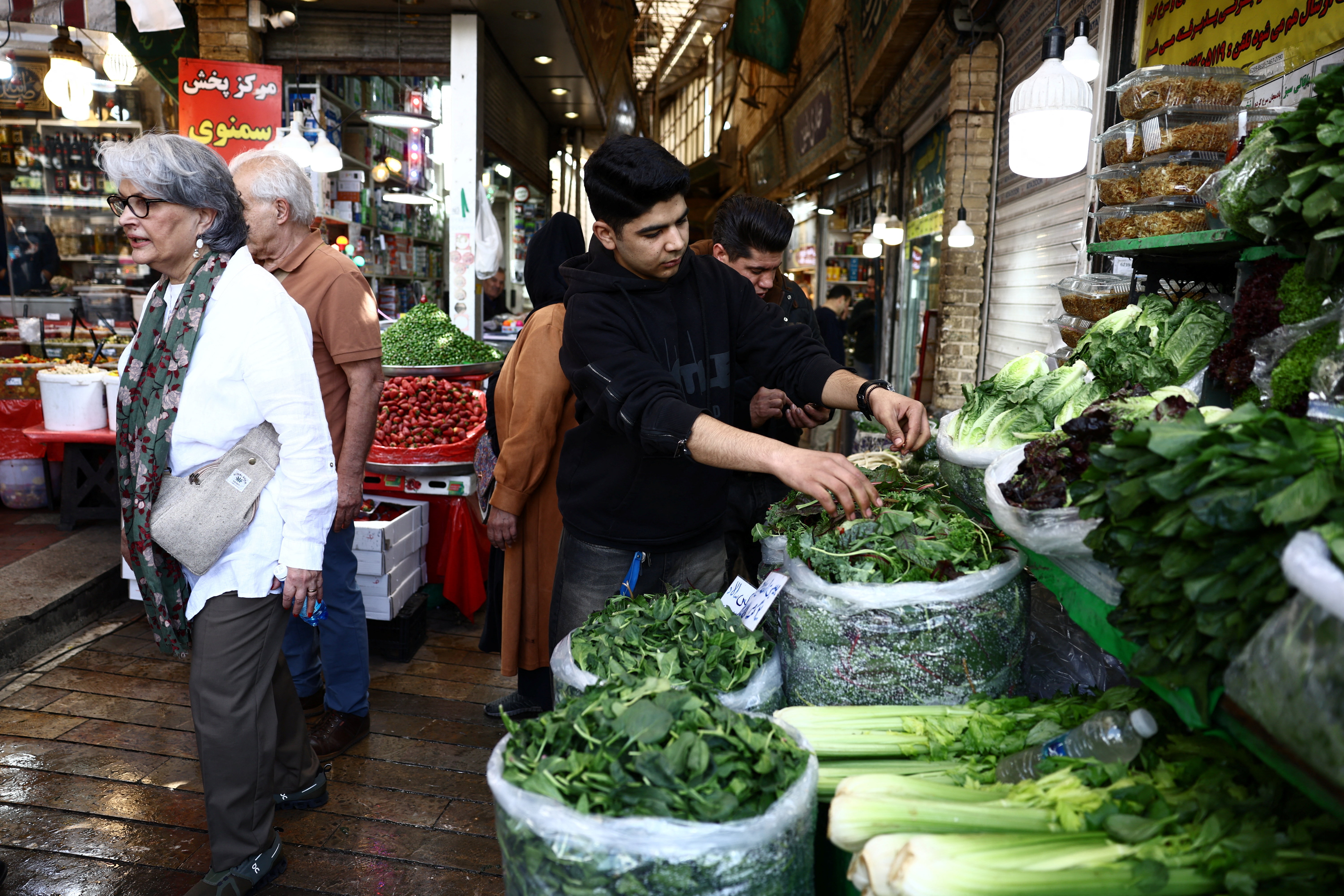 People shop at a market, amid the U.S.-Israeli conflict with Iran, in Tehran