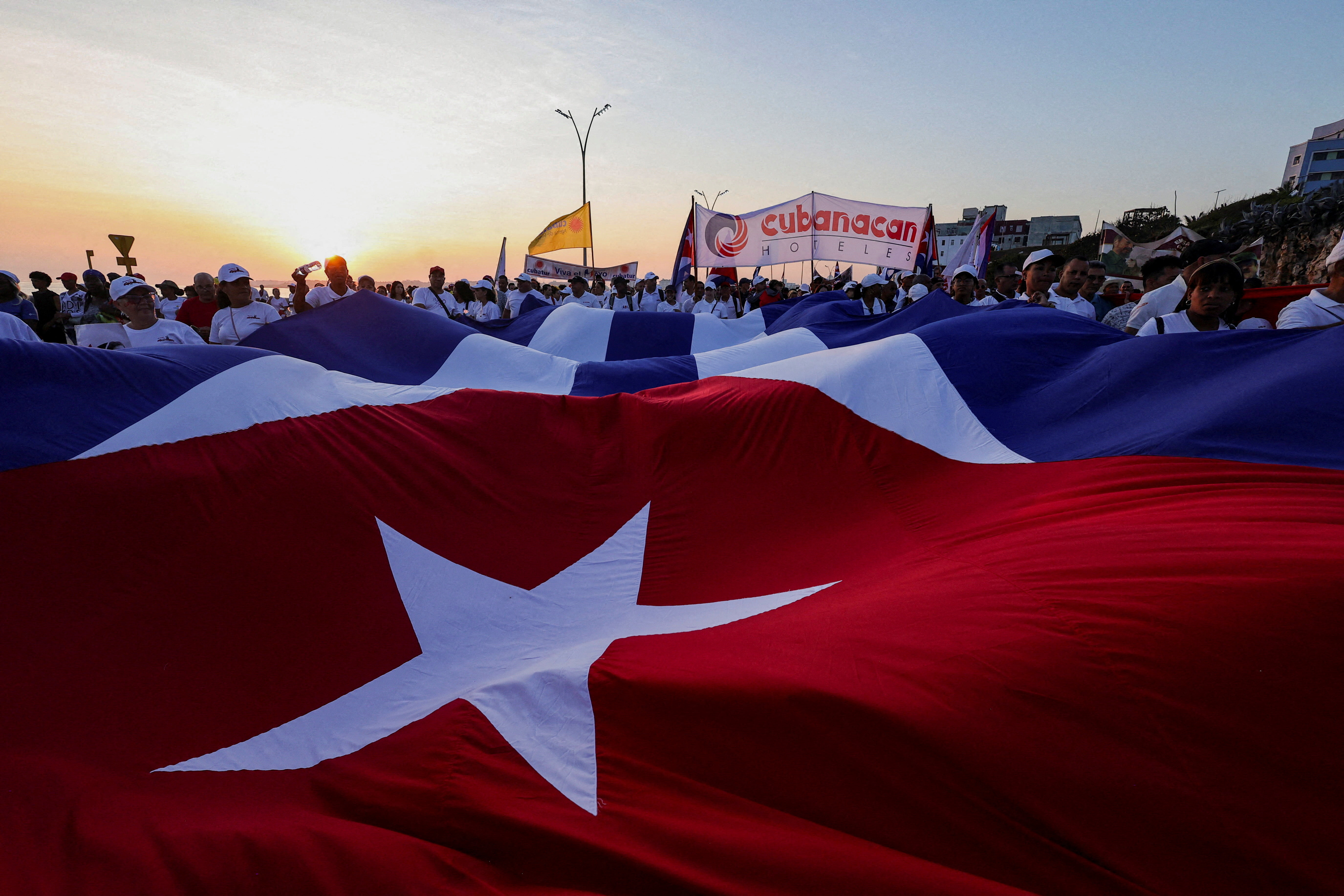 People march while holding a giant Cuban national flag during a May Day rally in Havana, Cuba, May 1, 2026. REUTERS/Claudia Daut TPX IMAGES OF THE DAY