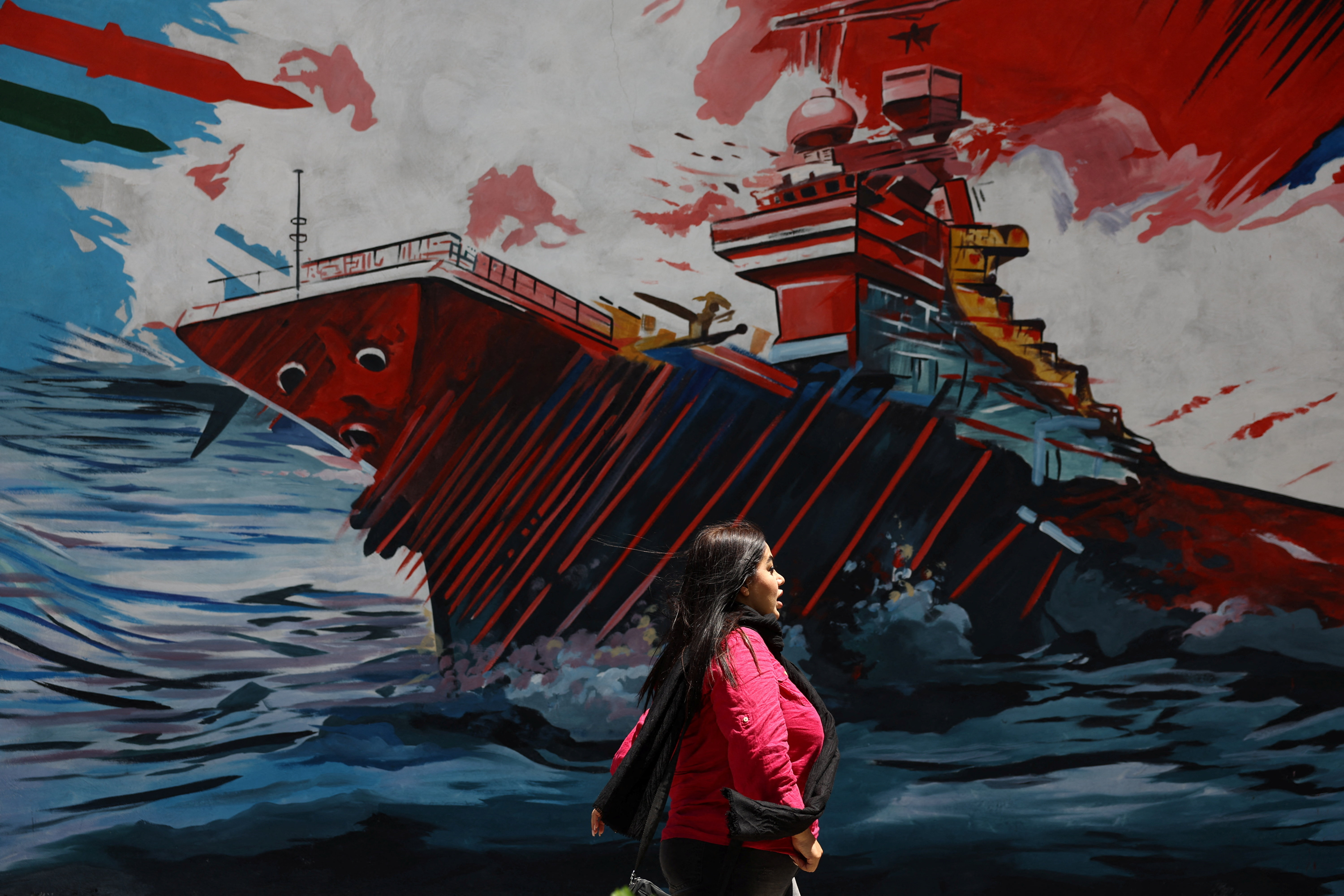 An Iranian woman walks next to a mural on a street in Tehran, Iran, May 6, 2026. Majid Asgaripour/WANA (West Asia News Agency) via REUTERS ATTENTION EDITORS - THIS PICTURE WAS PROVIDED BY A THIRD PARTY