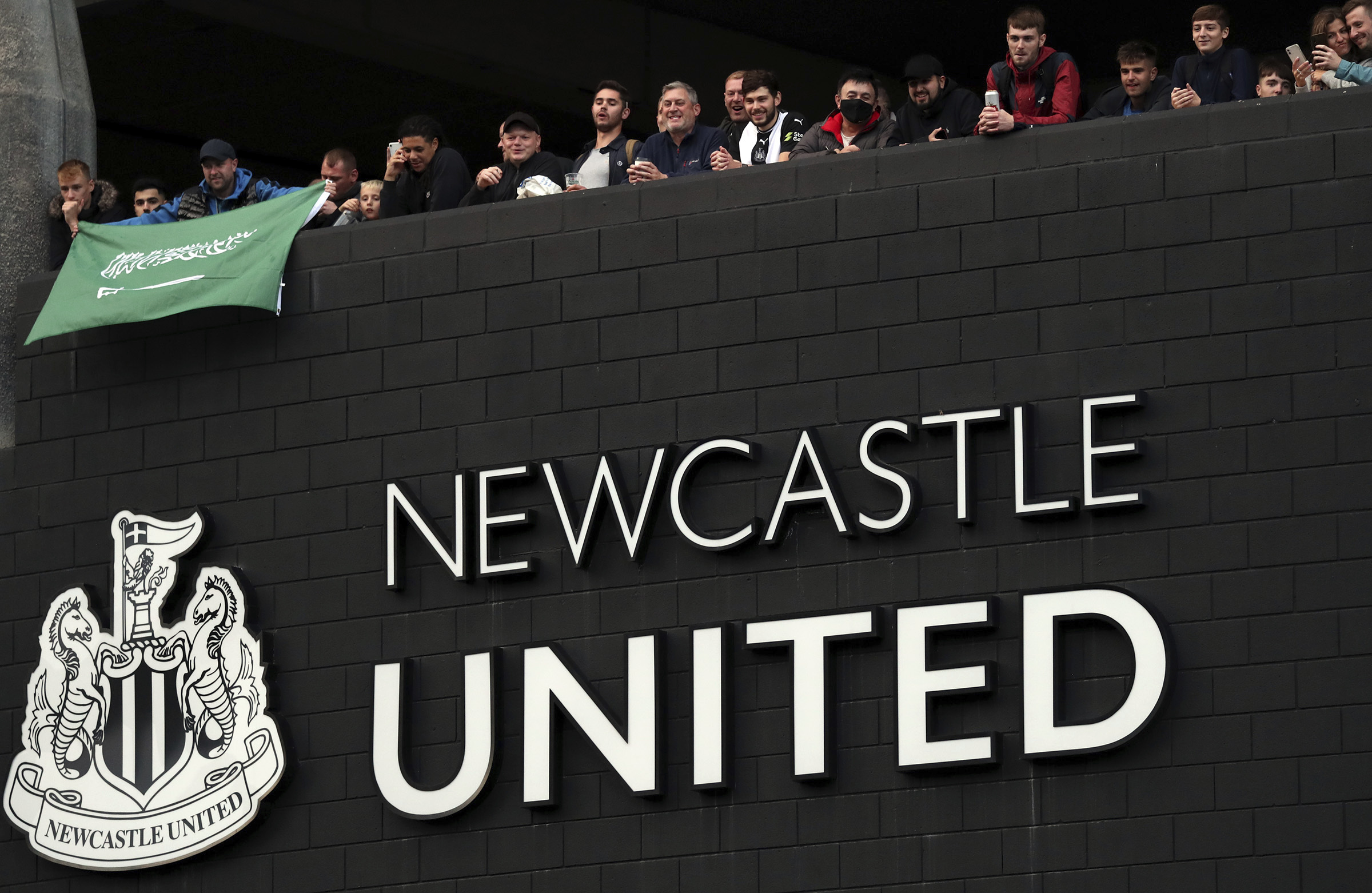 Newcastle United supporters celebrate outside St. James' Park in Newcastle Upon Tyne, England