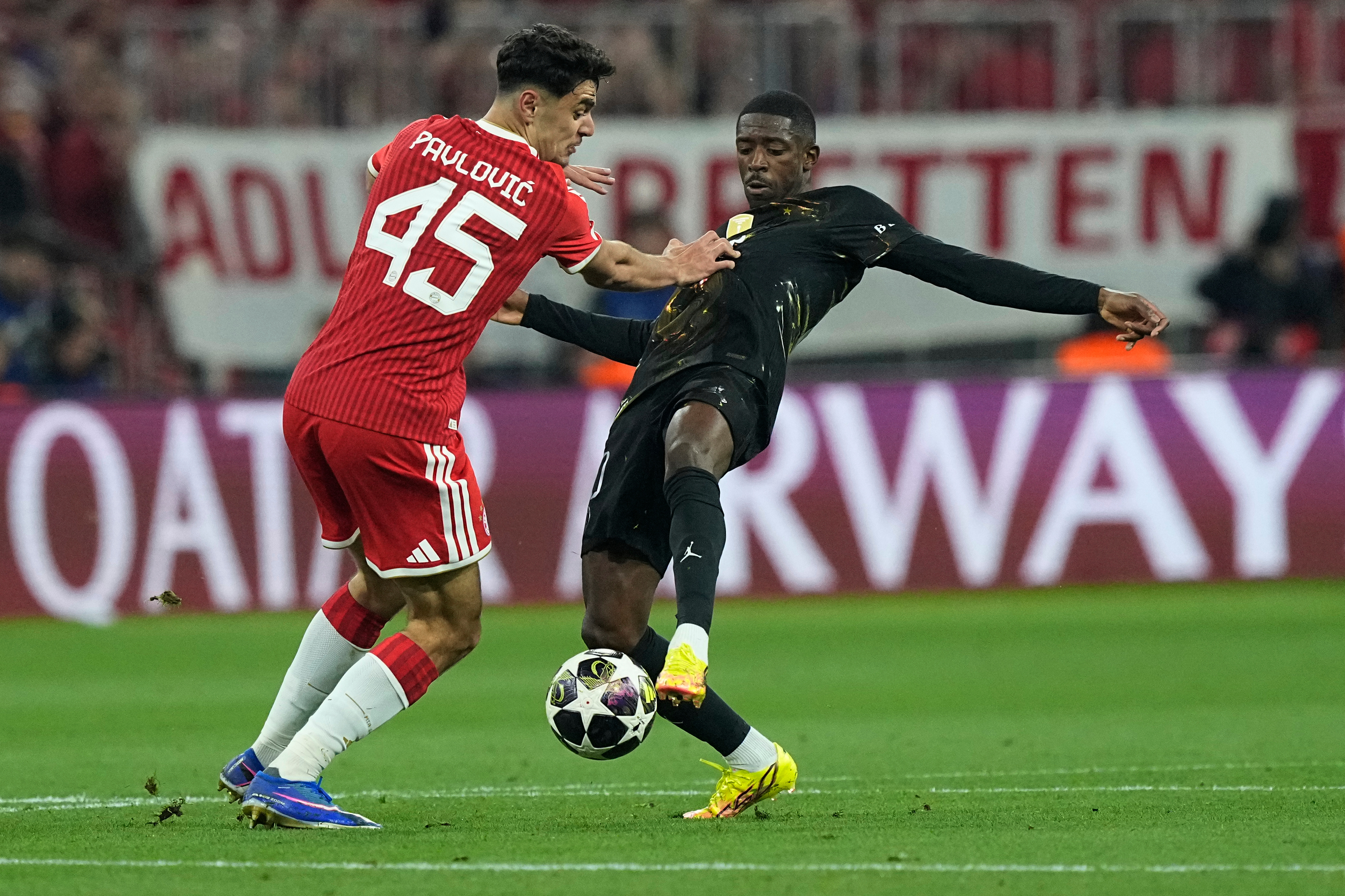 Bayern's Aleksandar Pavlovic, left, tries to stop PSG's Ousmane Dembele