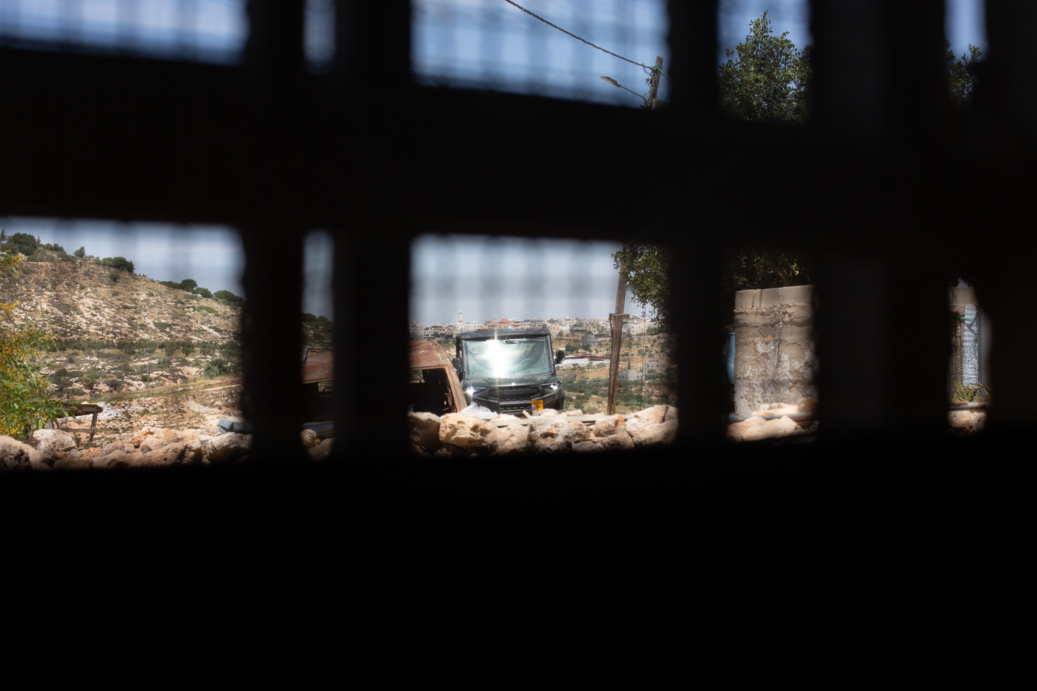 An ATV moves across the hills beyond an opening in the Masallam family compound in Khirbet al-Marajim [Al Jazeera]