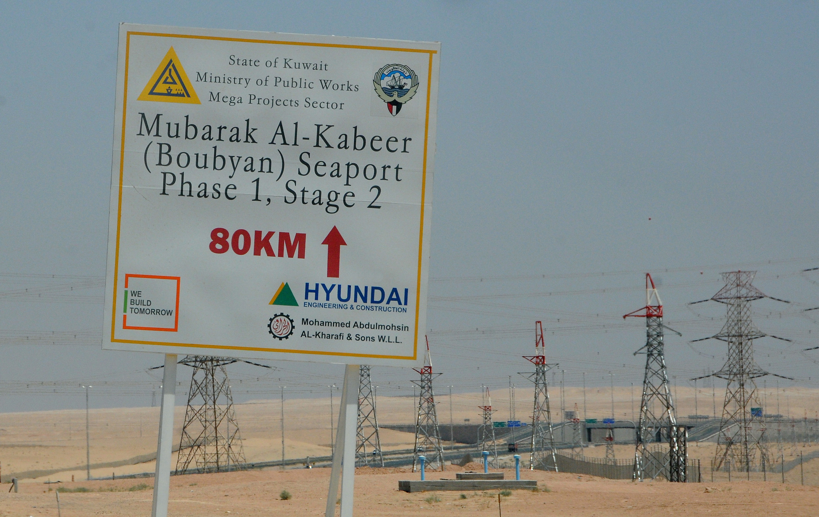 In this Aug. 20, 2011 photo, a sign is displayed leading to the construction site at the Mubarak al-Kabir port project on Bubiyan Island, Kuwait. Iraq and Kuwait, two countries that share a small border and big history of mutual suspicion and war, are at it again. This time they are arguing about Kuwaiti plans to build a mammoth port that Iraq claims interferes with its shipping lanes in the Gulf. (AP Photo/Gustavo Ferrari)