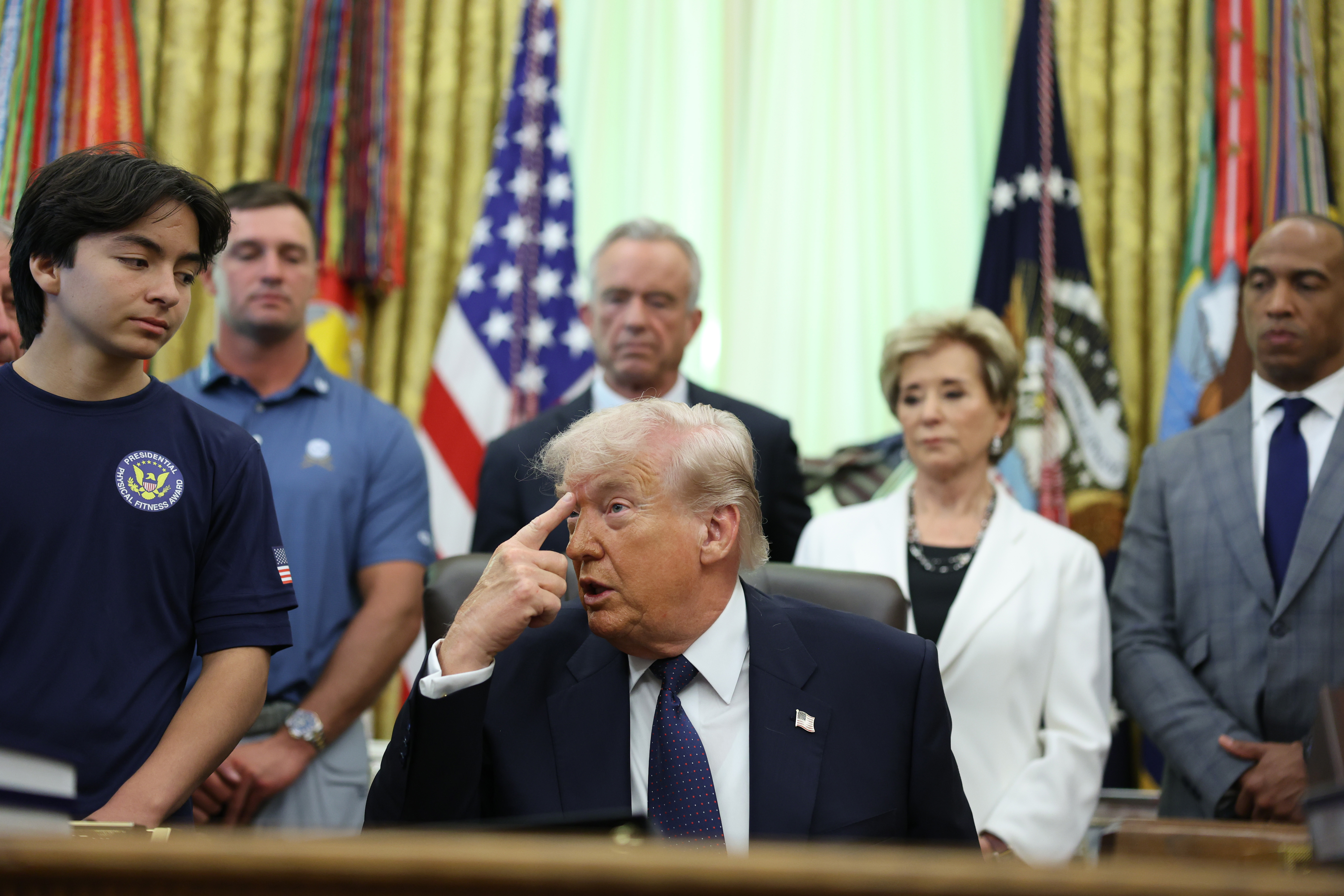epa12934561 US President Donald Trump gestures as he speaks during a proclamation signing with professional golfer Bryson DeChambeau (2-L), US Secretary of Health and Human Services Robert F. Kennedy Jr. (C), and US Education Secretary Linda McMahon (2-R) inside the Oval Office at the White House in Washington, DC, USA, 05 May 2026. The memorandum is set to restore the Presidential Fitness Test Award, a competitive school-based fitness program last seen under the Obama administration. EPA/TOM BRENNER / POOL