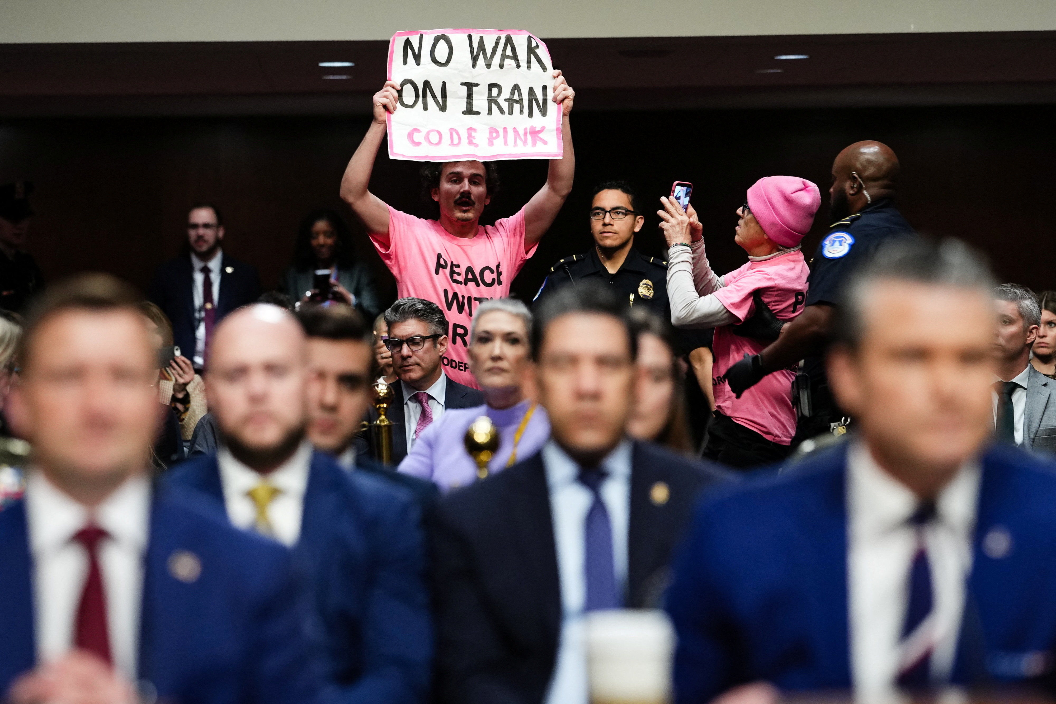 A protester holds a banner opposing the war with Iran during U.S. Defense Secretary Pete Hegseth's opening remarks at a Senate Armed Services Committee hearing on U.S. President Donald Trump's FY2027 budget request for the Department of Defence on Capitol Hill in Washington, D.C., U.S., April 30, 2026. REUTERS/Eric Lee TPX IMAGES OF THE DAY