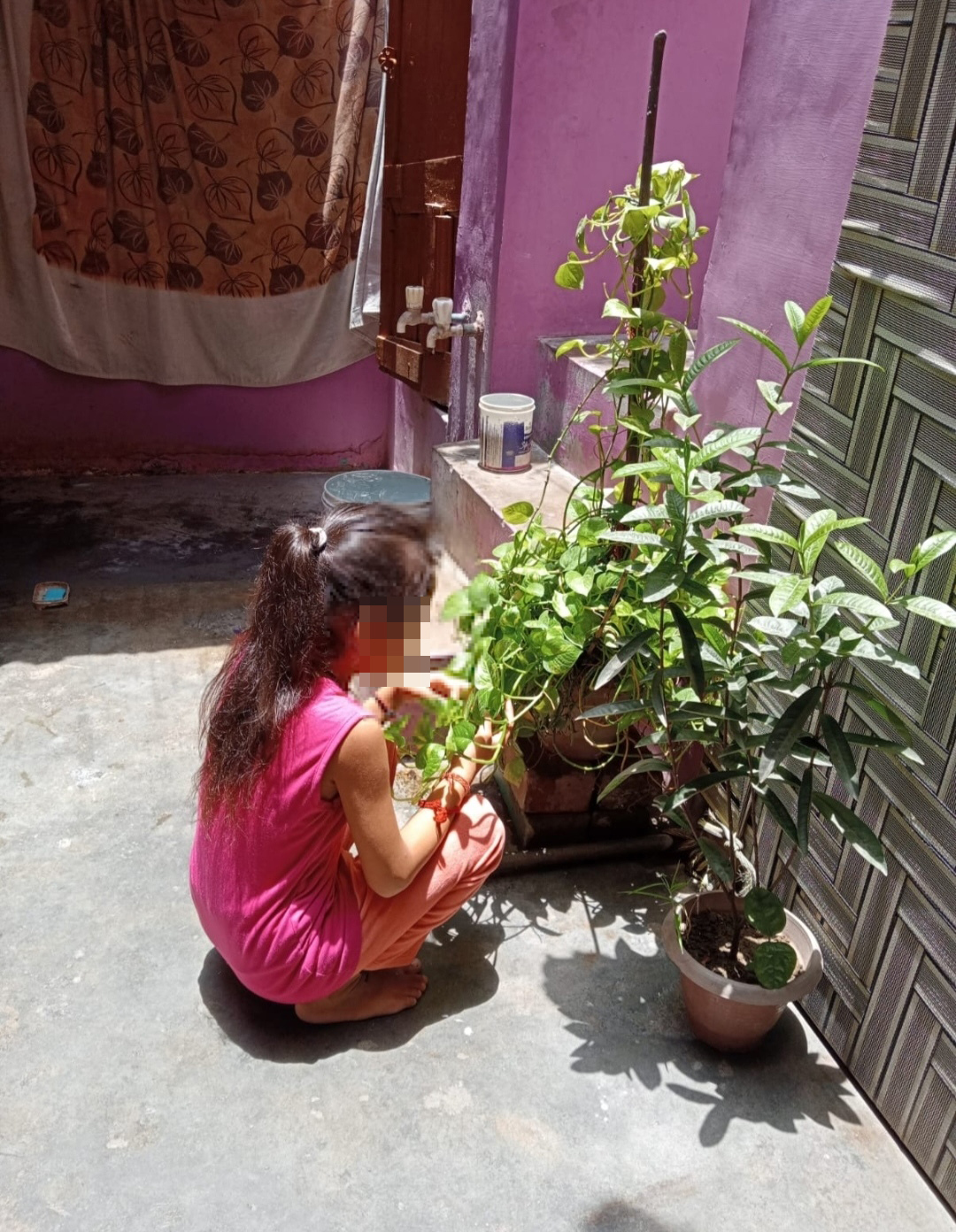 Pia tends to her plants on the family's shared terrace [Courtesy of the family/Al Jazeera]