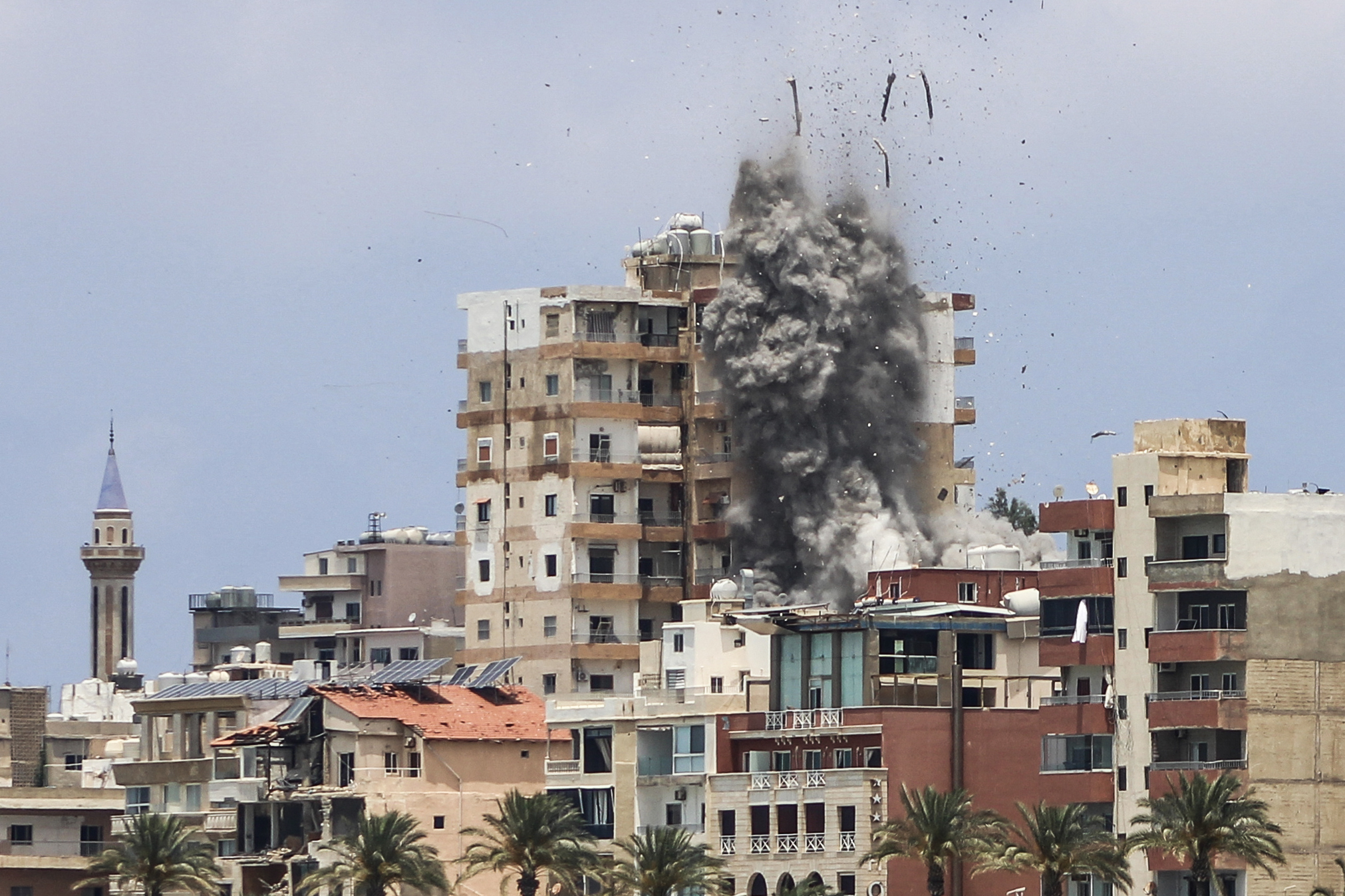 Smoke and debris rise above a city.
