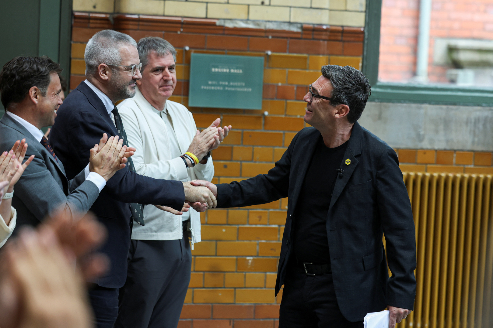 Andy Burnham, British member of parliament (MP) for Makerfield, shakes hands with South Yorkshire Mayor Oliver Coppard as he arrives to deliver a speech at the People's History Museum in Manchester, Britain, June 29, 2026. [REUTERS/Temilade Adelaja]