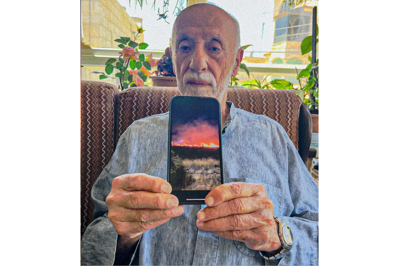 Yasser Saqer Rashid, a 92-year-old Palestinian-American, displays a photo on his phone following a settler arson attack inside a mosque in Deir Dibwan.