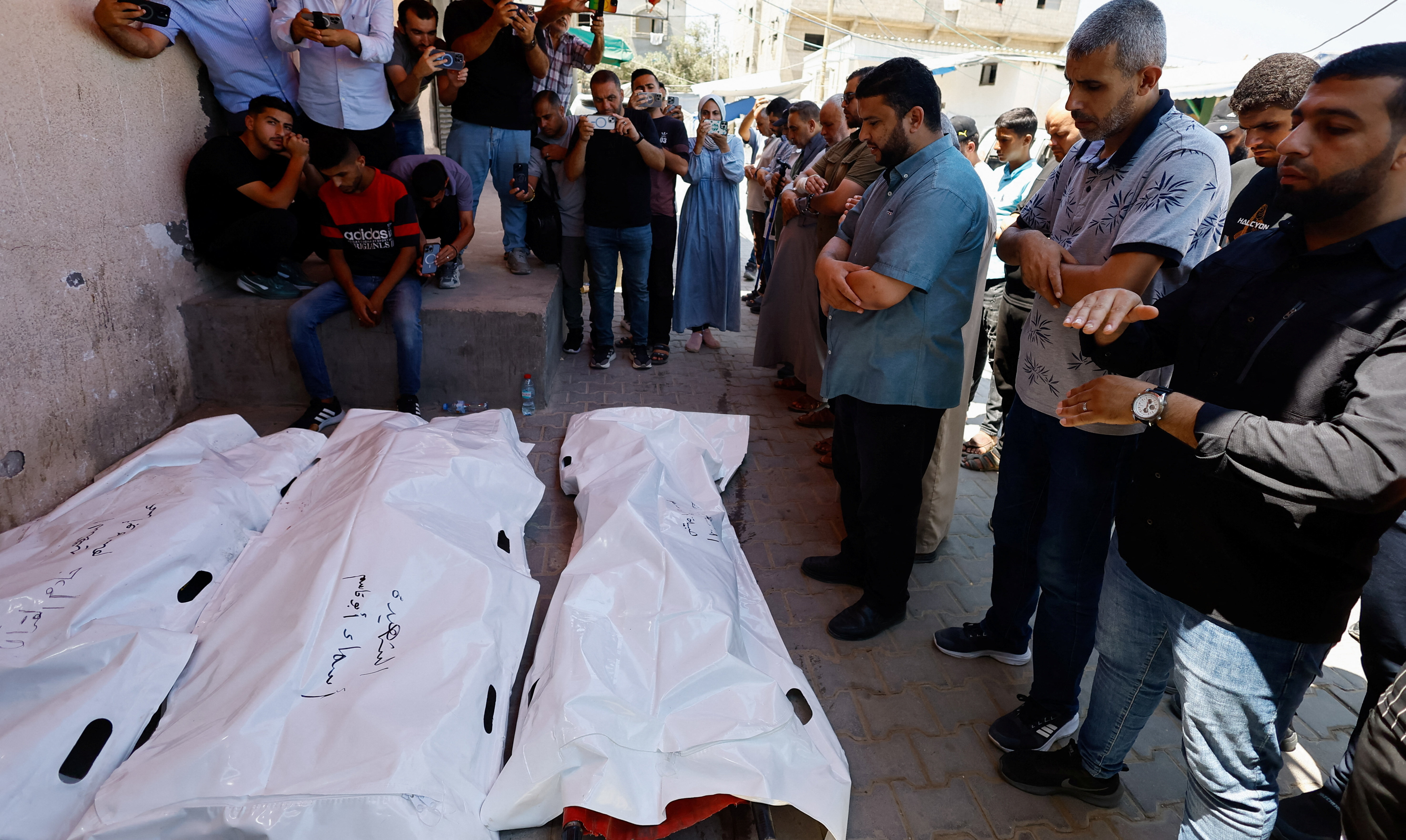 Mourners pray during the funeral of Palestinian man Omar Abu Qassem, his wife Asma, and their daughter Habeeba, who were killed in an Israeli strike on Wednesday, at Al-Aqsa Martyrs hospital in Deir Al-Balah, in the central Gaza Strip, July 15, 2026. REUTERS/Mahmoud Issa
