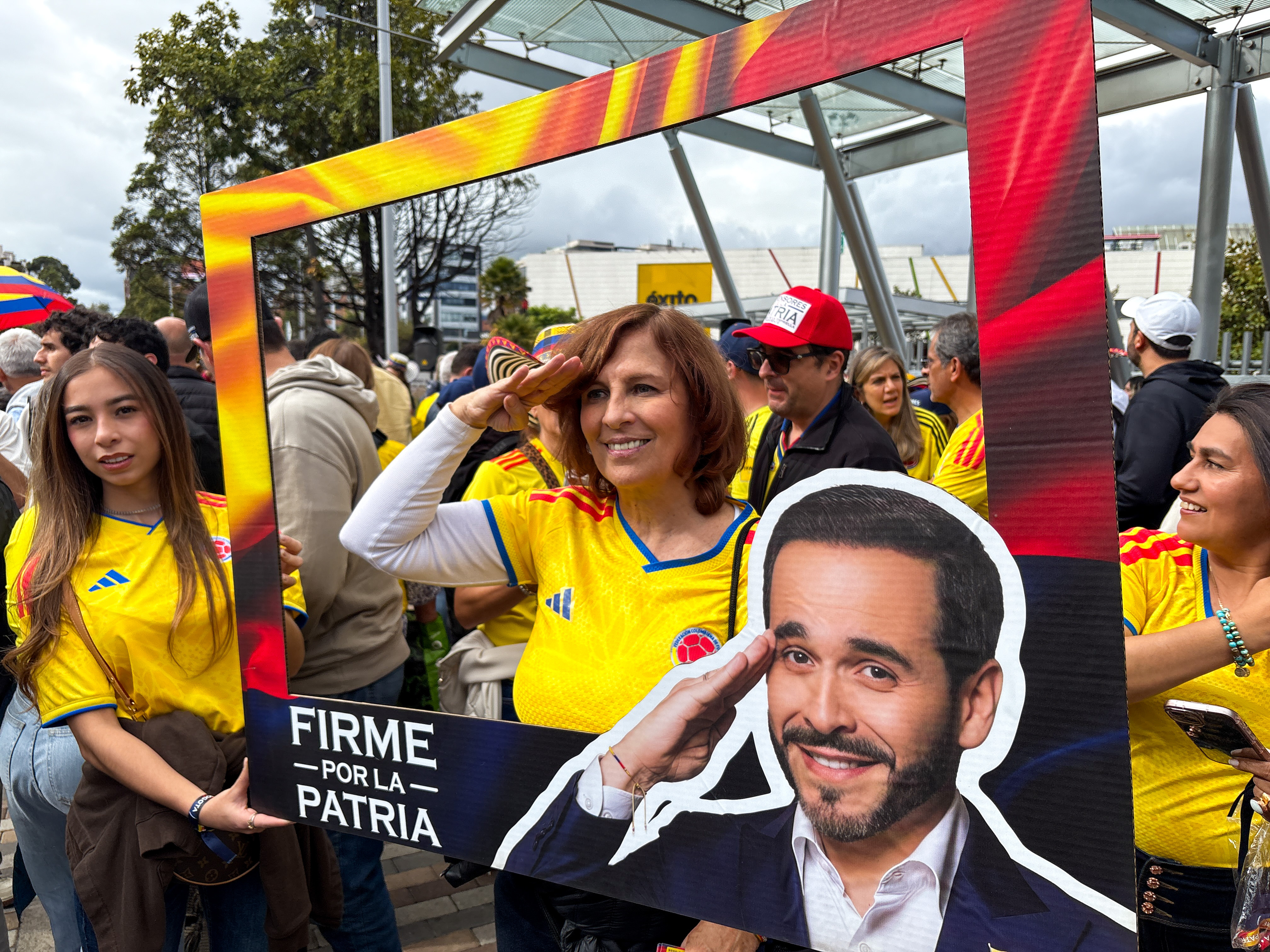 A supporter of Abelardo de la Espriella poses in a cut-out frame, wearing her football jersey