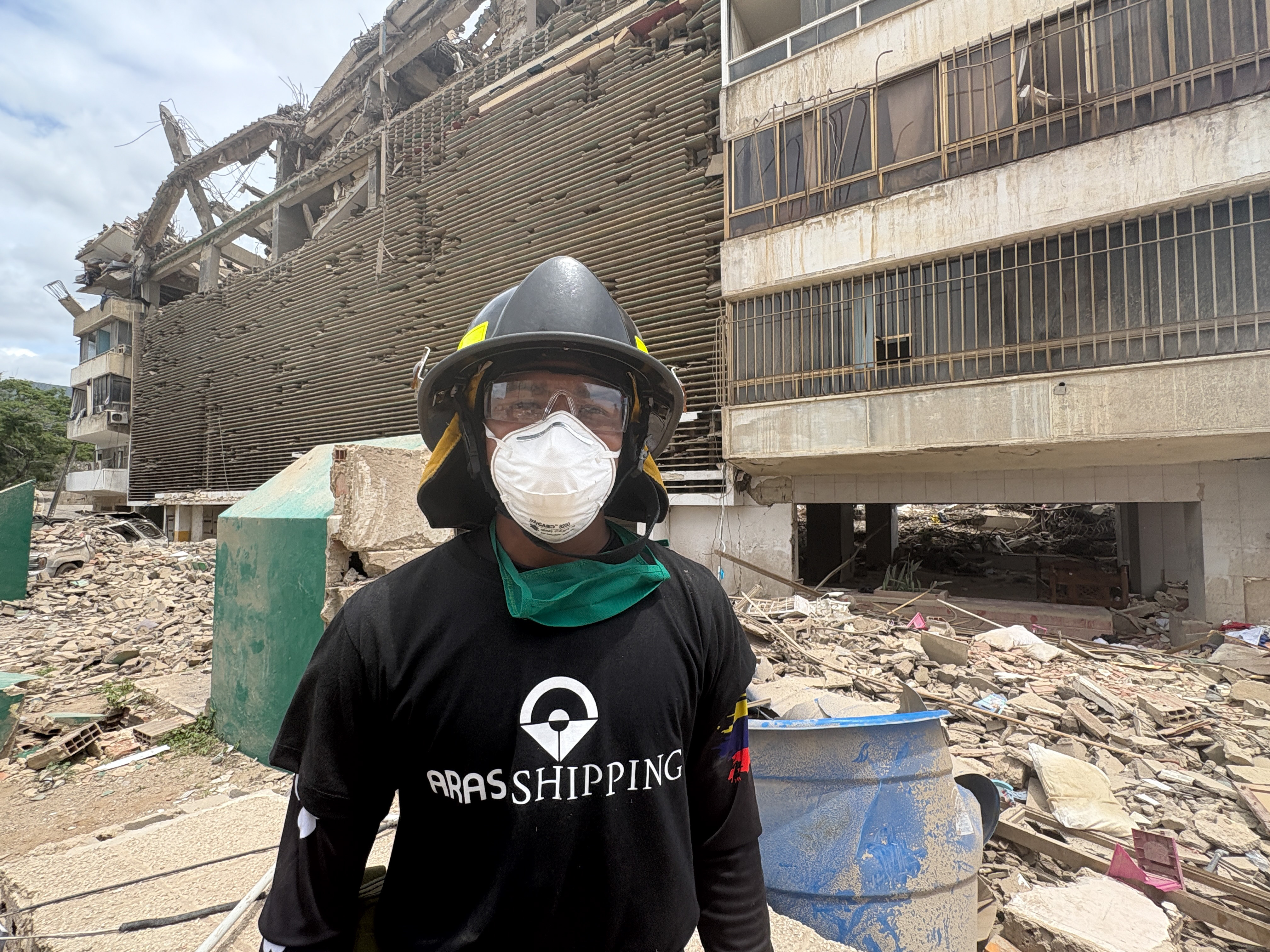 Jeff Sombrito next to earthquake rubble