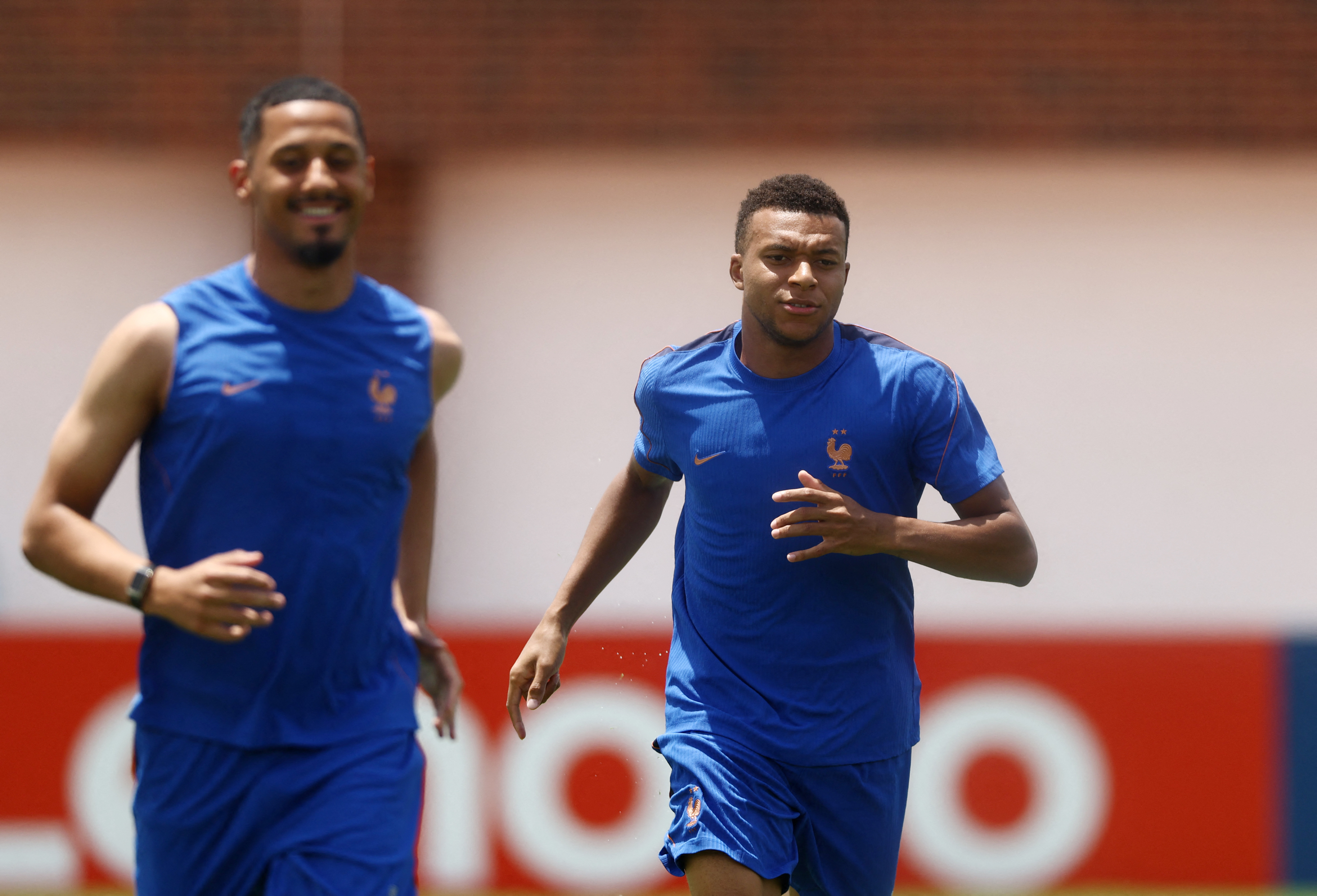France's Kylian Mbappe and William Saliba running.