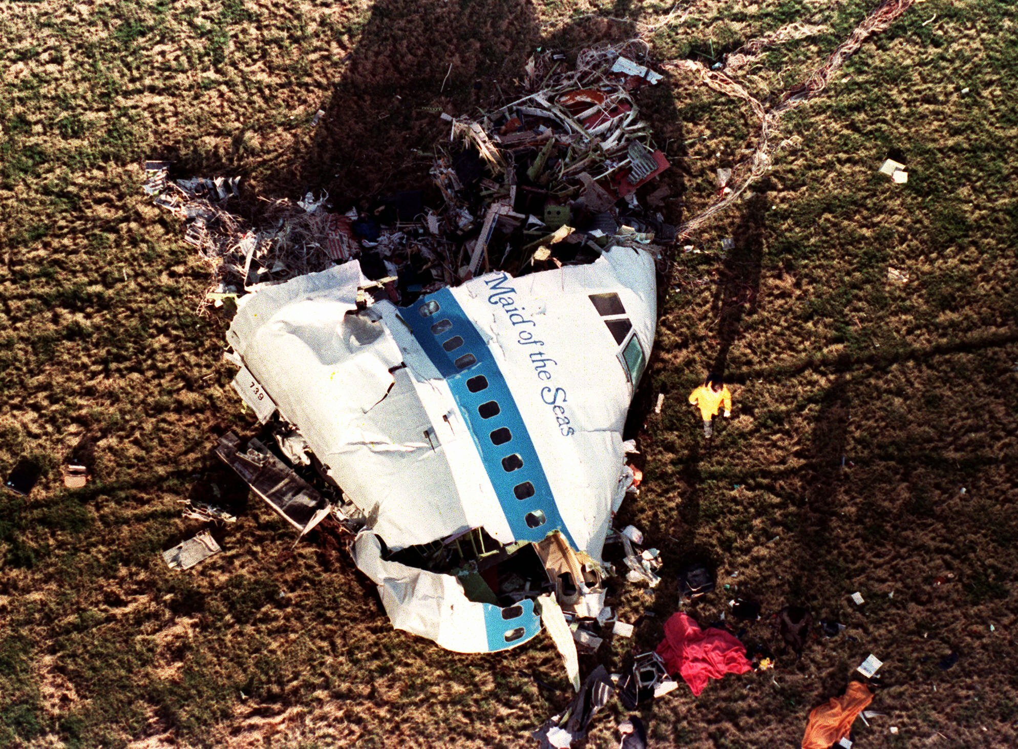 FILE - In this Dec. 22, 1988, file photo police and investigators look at what remains of the nose of Pan Am 103 in a field in Lockerbie, Scotland. The Justice Department expects to unseal charges in the coming days in connection with the 1988 bombing of a Pan Am jet that exploded over Lockerbie, Scotland, killing 270 people, according to a person familiar with the case. (AP Photo/Martin Cleaver, File)