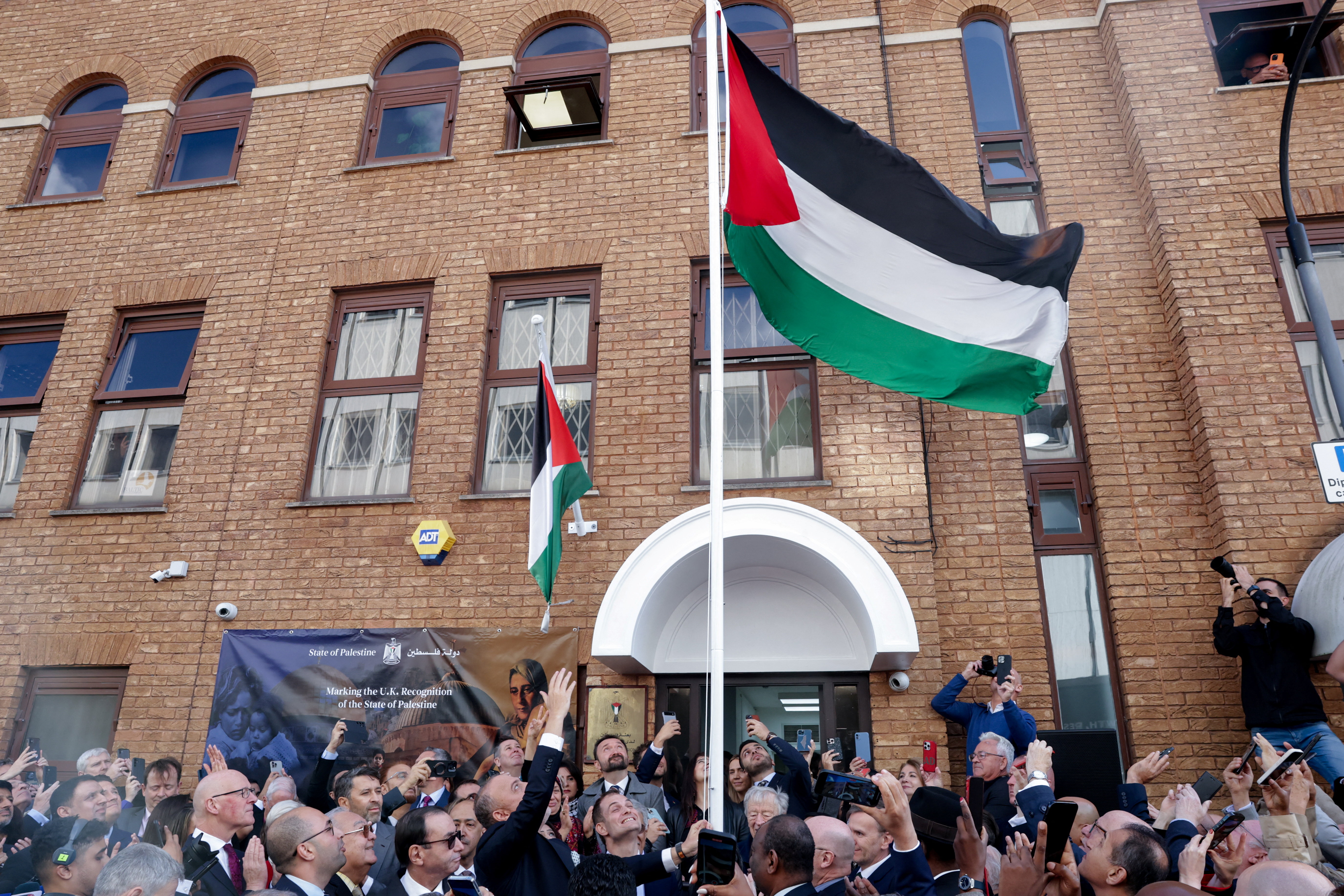 The Palestinian flag is raised as the Palestinian mission to the United Kingdom holds a ceremony after the British government announced on Sunday the country's formal recognition of a Palestinian state, at the mission's headquarters in London, Britain, September 22, 2025. REUTERS/Toby Melville