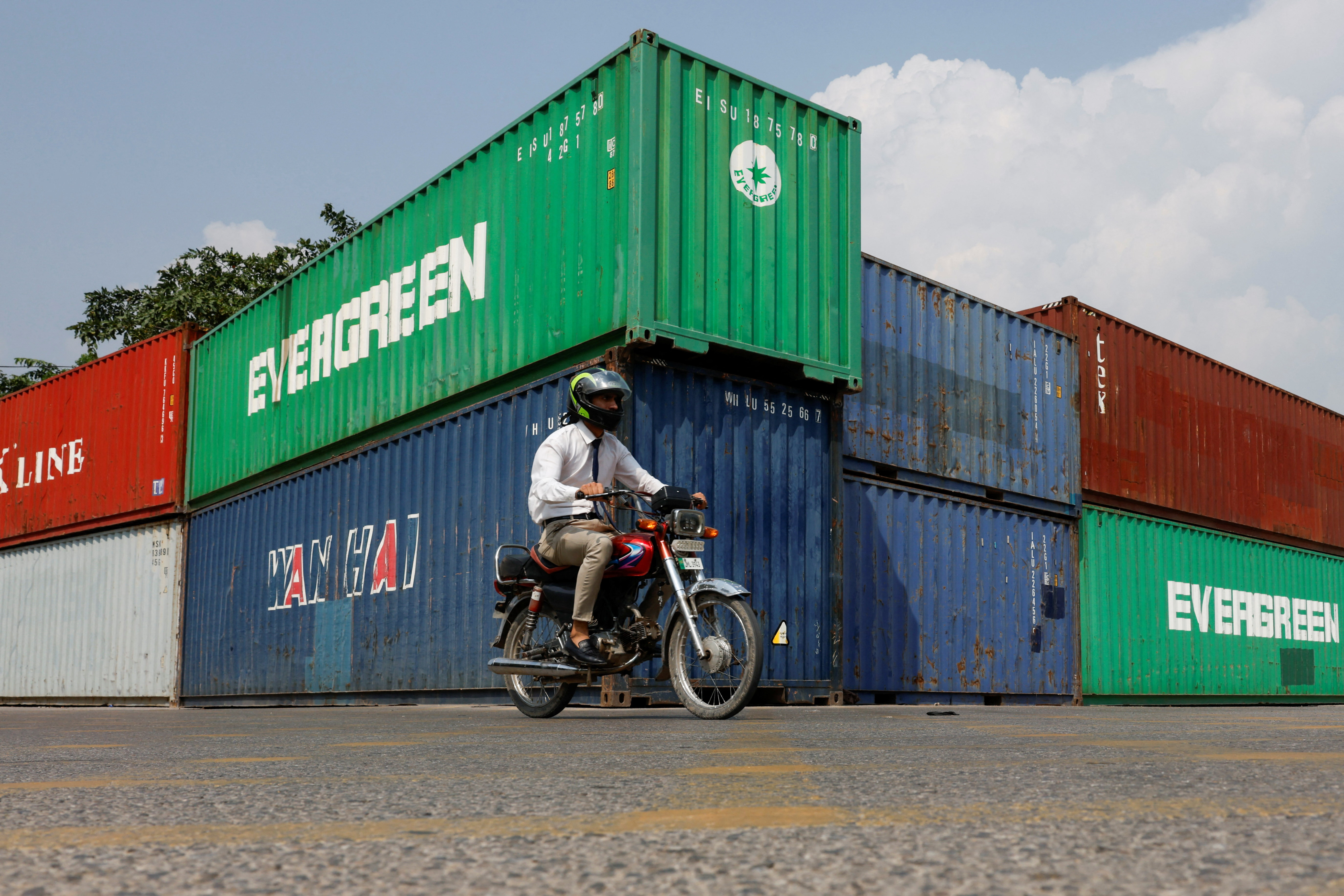 A man rides a motorcycle past shipping containers used to block the area ahead of a planned march by former Pakistani Prime Minister Imran Khan's party, demanding his release and calling for the supremacy of the Constitution and restoration of the rule of law across the country, in Islamabad, Pakistan, September 23, 2026. REUTERS/Akhtar Soomro