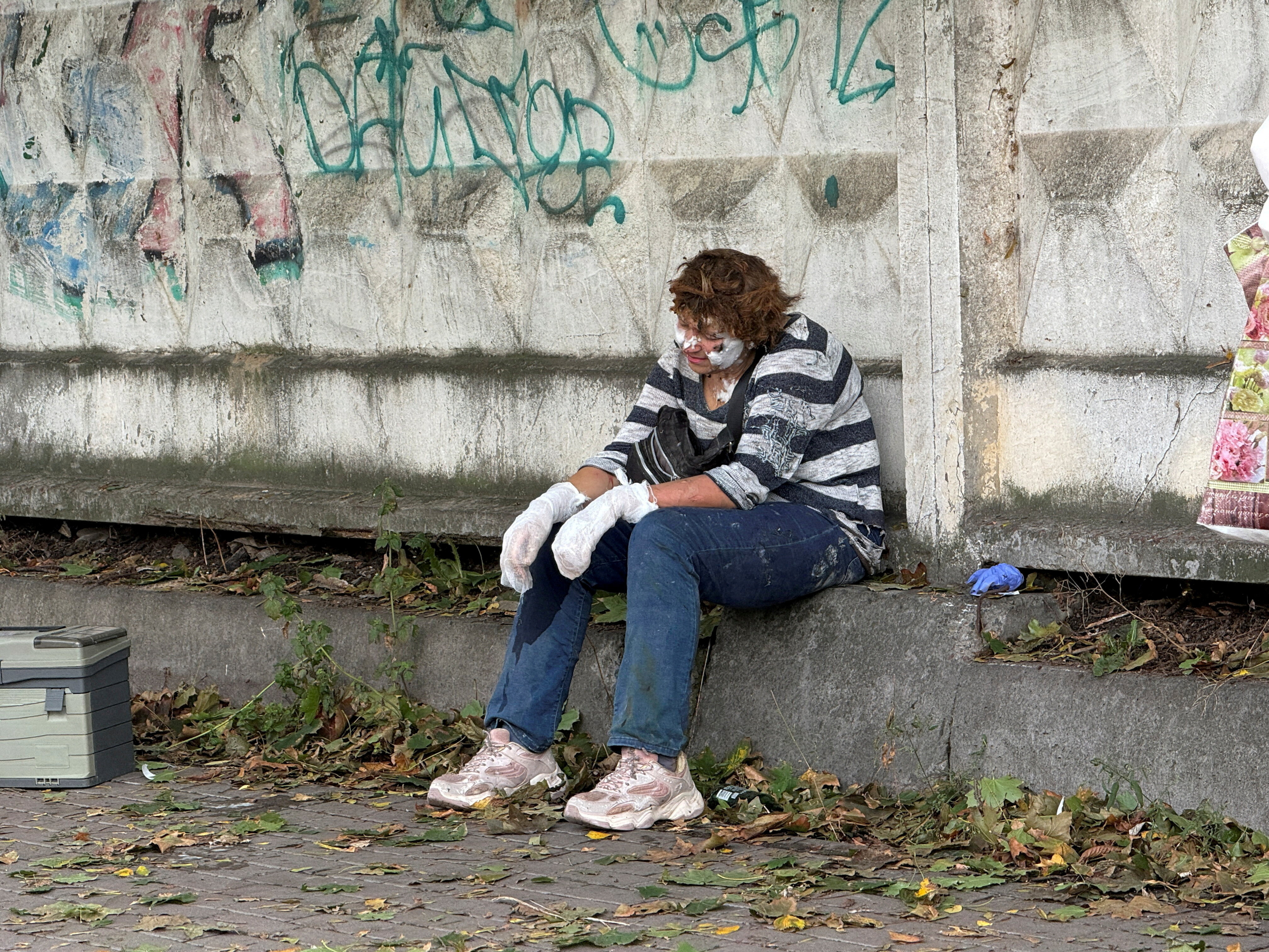 A wounded women sits near a business center hit by a Russian drone strike, amid Russia's attack on Ukraine in Kyiv, Ukraine September 23, 2026. Picture taken with a mobile phone. REUTERS/Stringer TPX IMAGES OF THE DAY