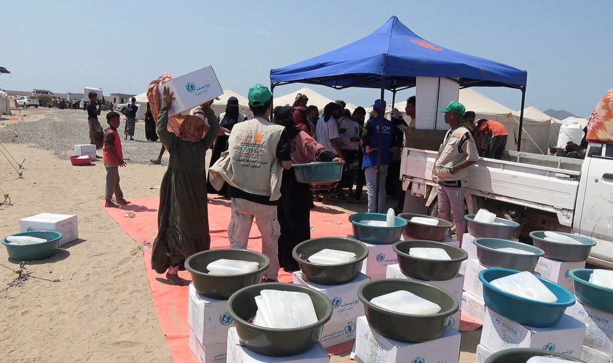 People who fled fighting between the Houthis and government forces in Red Sea coastal areas hold food they received at a camp for internally displaced people near Aden, Yemen, on September 23, 2026 [Reuters]