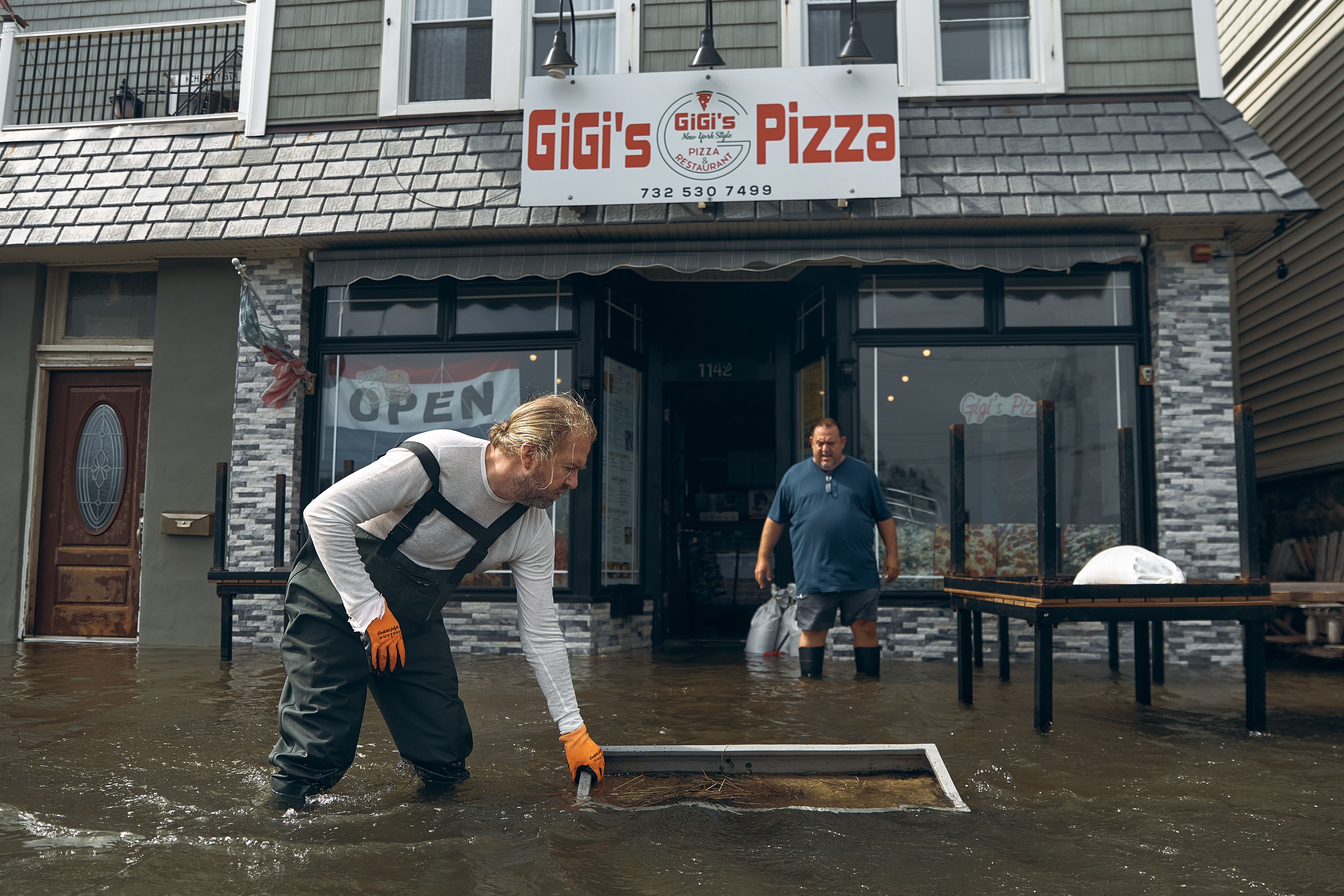 People clean a flooded pizza restaurant during a nor'easter storm on Sunday, September 27, 2026, in Sea Bright, New Jersey, US [Andres Kudacki/ AP Photo]