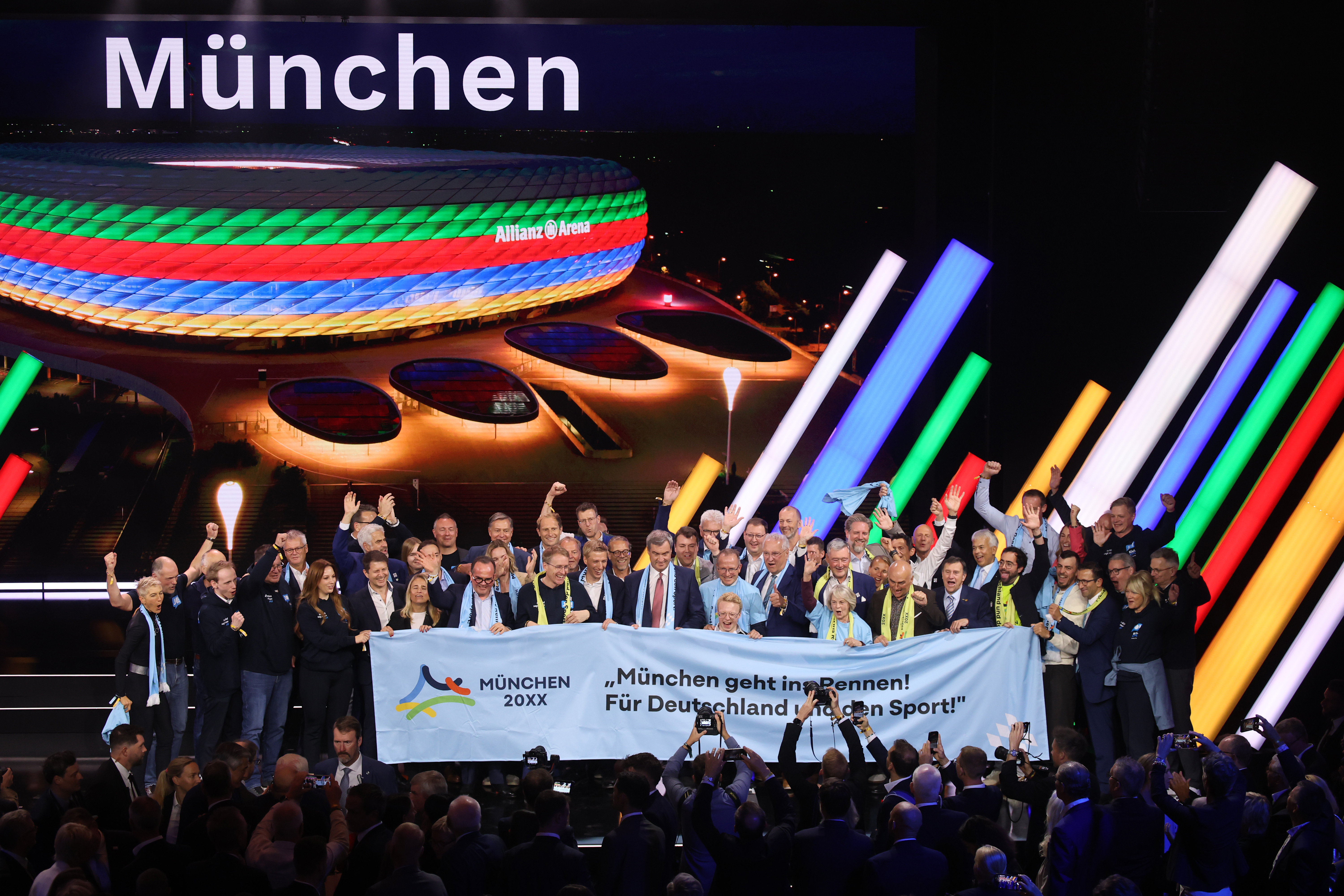 BADEN-BADEN, GERMANY - SEPTEMBER 26: Members of the Munich delegation celebrate on stage at after Munich was selected as Germany’s candidate for a future Olympic bid during the extraordinary German Olympic Sports Confederation (DOSB) general assembly at Kurhaus Baden-Baden on September 26, 2026 in Baden-Baden, Germany. At the DOSB's extraordinary general assembly, delegates will be able to vote on bids for either Munich or the KölnRheinRuhr region to compete to host the 2036, 2040 or 2044 Olympic and Paralympic Games. (Photo by Alex Grimm/Getty Images)