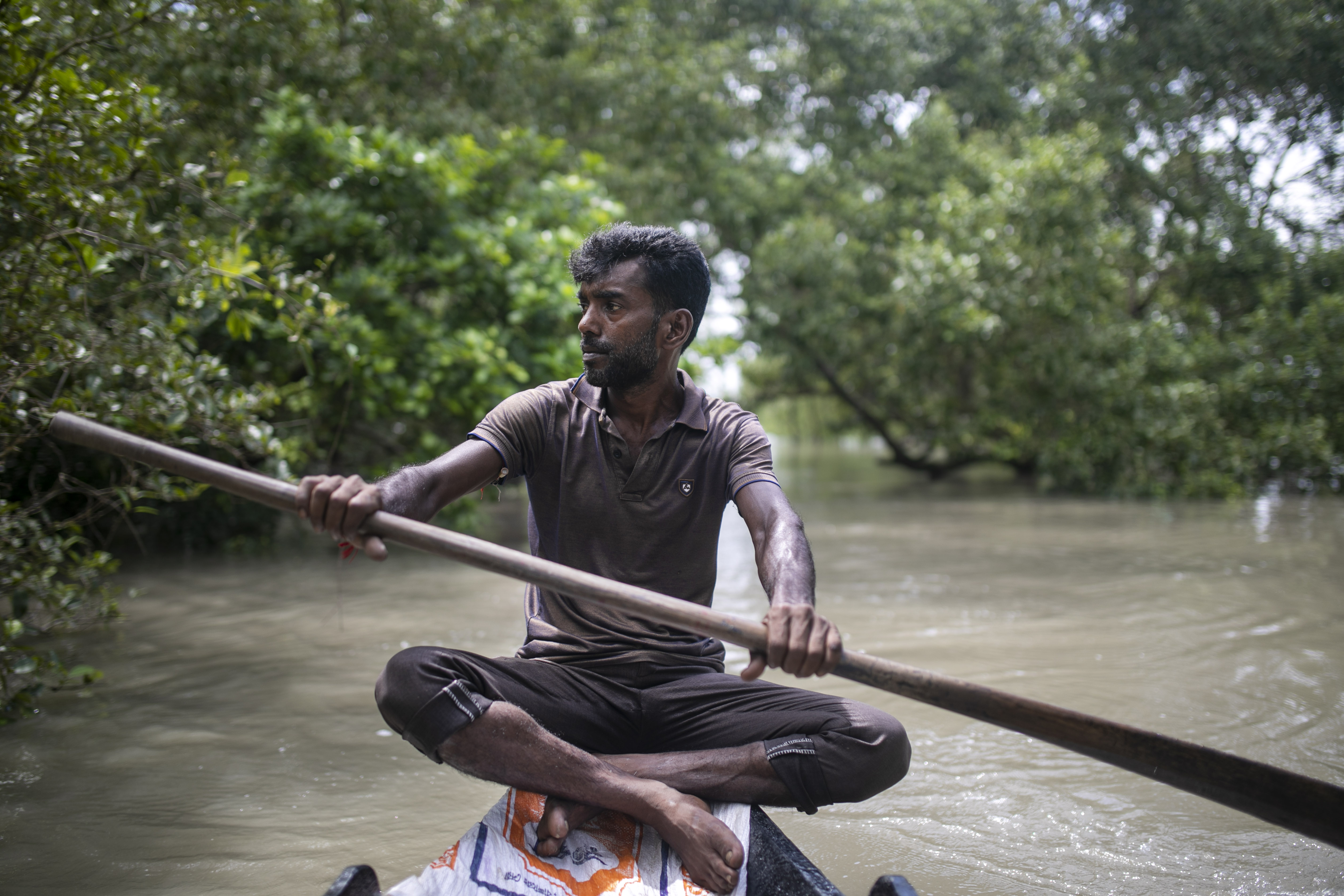 Suranjan Raptan crosses the Shakbaria River in his uncle’s boat