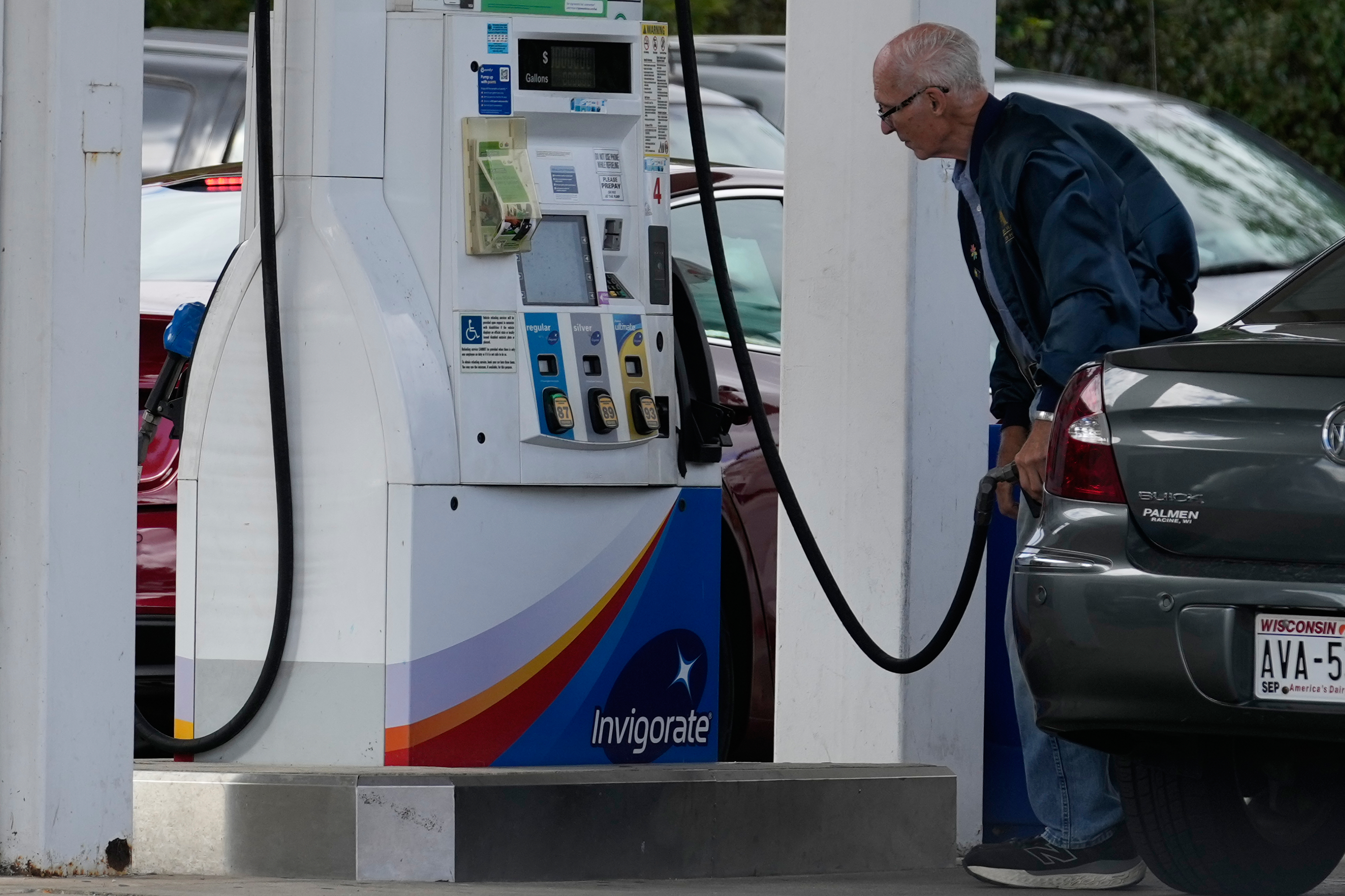 A customer checks gas price while he fills up his vehicle's tank at a gas station in Racine, Wis., Tuesday, Sept. 22, 2026. (AP Photo/Nam Y. Huh)