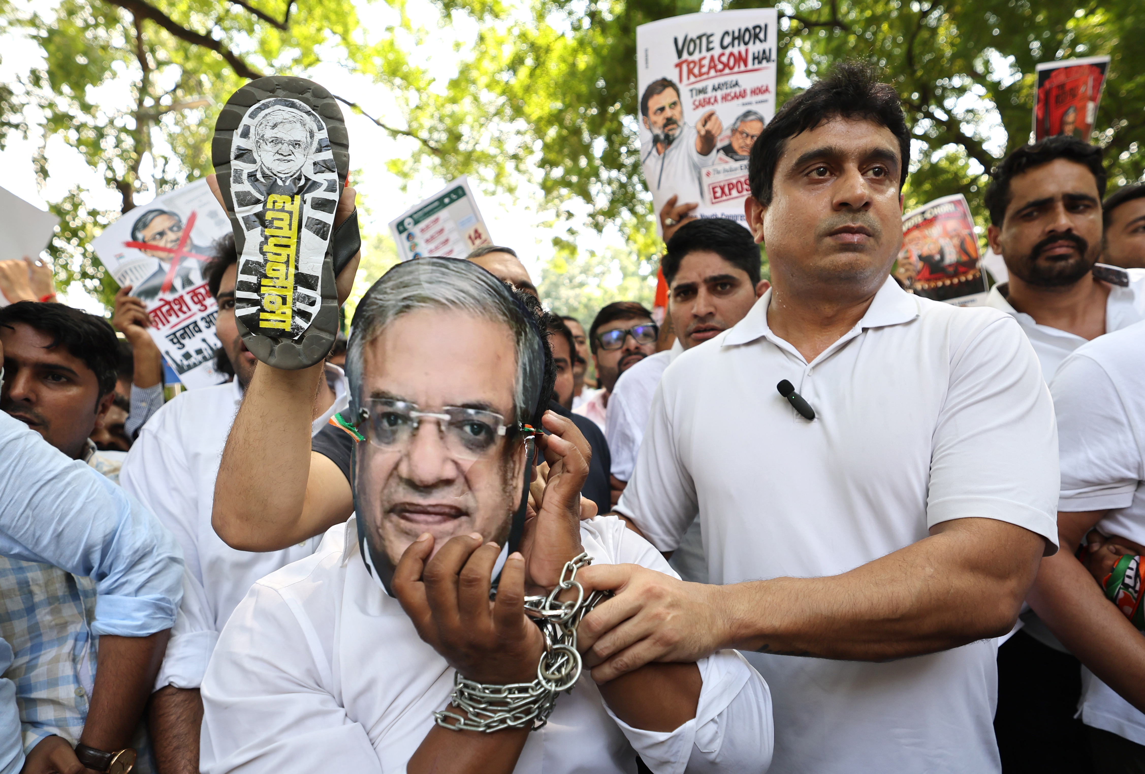 epa13262137 An Indian Youth Congress activist, wearing a mask depicting Chief Election Commissioner Gyanesh Kumar and handcuffed, takes part in a protest in New Delhi, India, 25 September 2026. Demonstrators gathered to demand Gyanesh Kumar's resignation over controversies surrounding the Election Commission's Special Intensive Revision (SIR) of electoral rolls and alleged voter irregularities during recent elections. EPA/RAJAT GUPTA