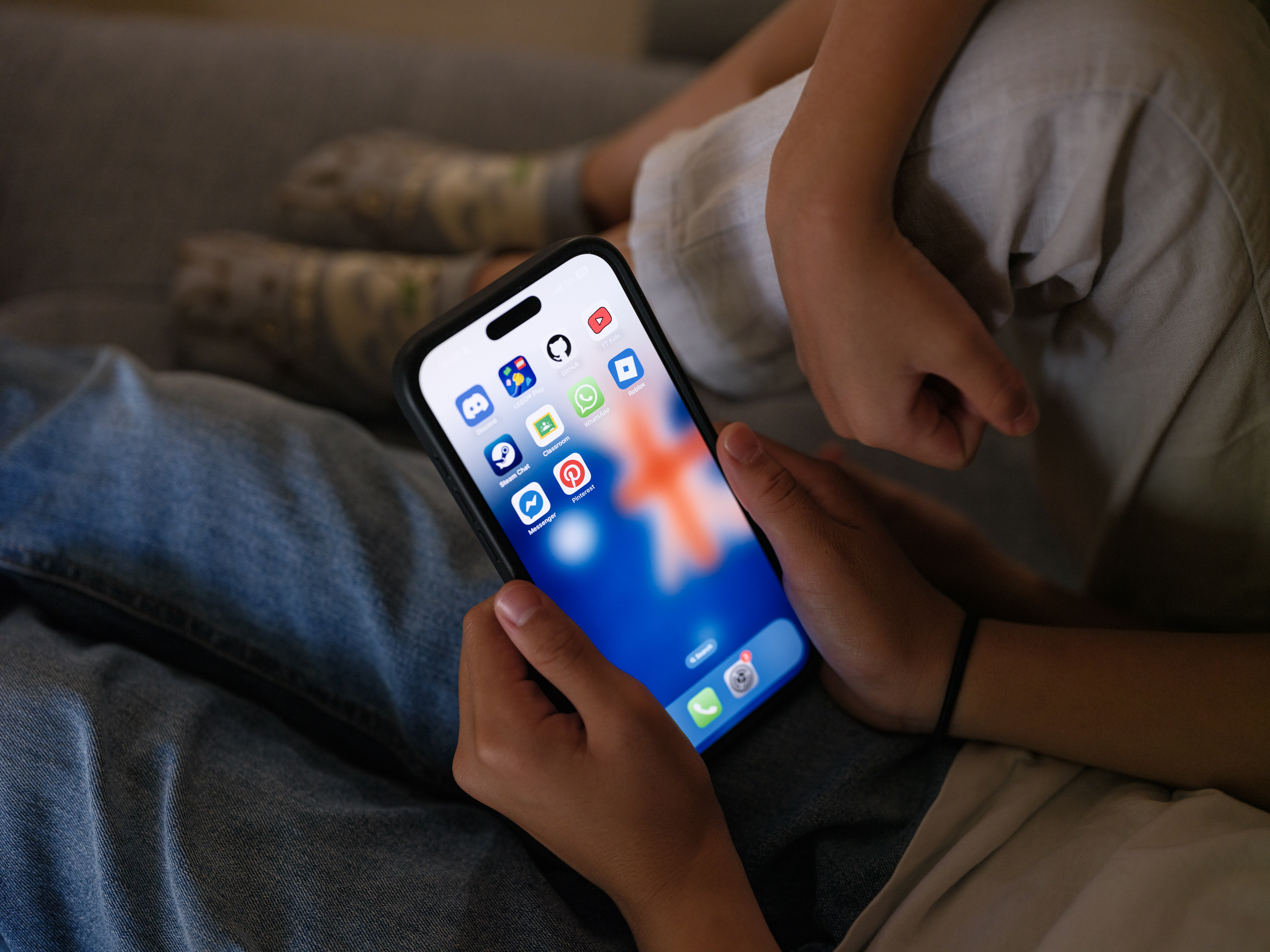 A 7-year-old teenage boy and a 11-year-old teenage girl look at a phone screen with social media networking apps are displayed on December 07, 2025 in Sydney, Australia. [George Chan/Getty Images]