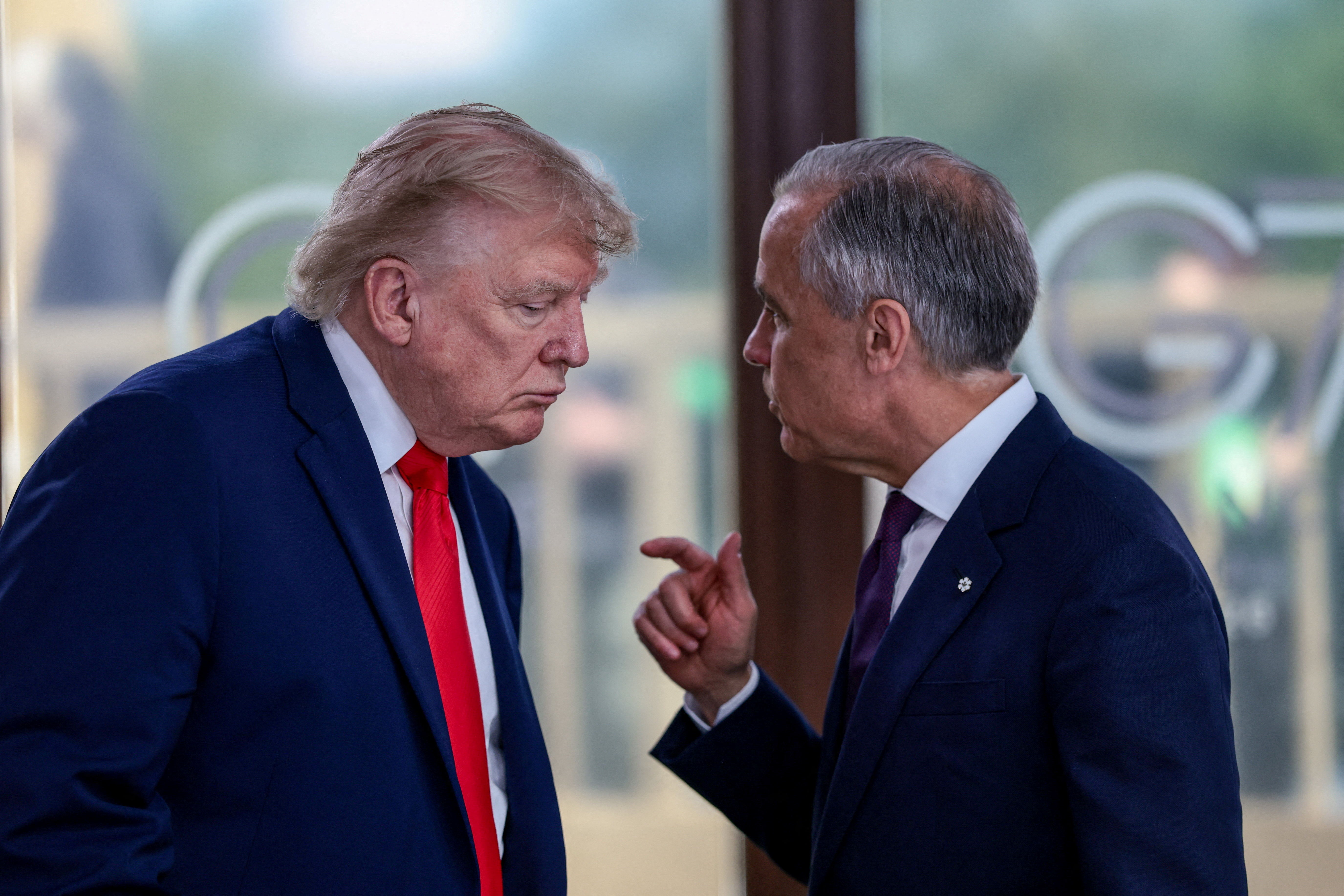 U.S. President Donald Trump speaks with Canadian Prime Minister Mark Carney at a working lunch with leaders of G7 and the Middle East, in Evian-les-Bains, France, June 16, 2026. [Evelyn Hockstein/Reuters]