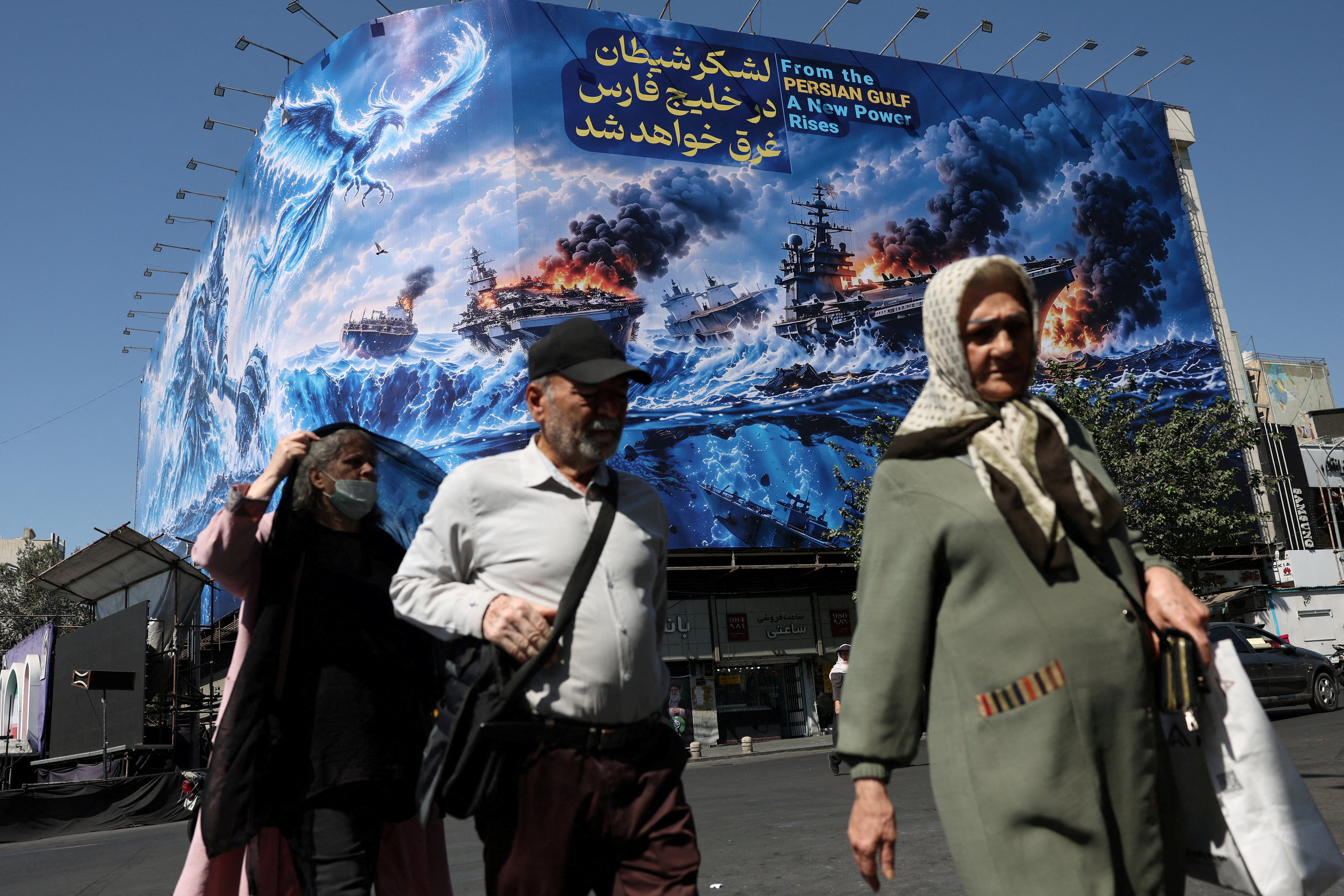 FILE PHOTO: People walk past a billboard about the Strait of Hormuz, on a building in Tehran, Iran, September 16, 2026. Majid Asgaripour/WANA (West Asia News Agency) via REUTERS ATTENTION EDITORS - THIS PICTURE WAS PROVIDED BY A THIRD PARTY. ISRAEL OUT. NO COMMERCIAL OR EDITORIAL SALES IN ISRAEL. NO ACCESS FOR ISRAELI MEDIA. NO USE BBC PERSIAN. NO USE VOA PERSIAN. NO USE MANOTO. NO USE IRAN INTERNATIONAL. NO USE RADIO FARDA. DIGITAL: NO USE BBC PERSIAN. NO USE VOA PERSIAN. NO USE MANOTO. NO USE IRAN INTERNATIONAL. NO USE RADIO FARDA./File Photo