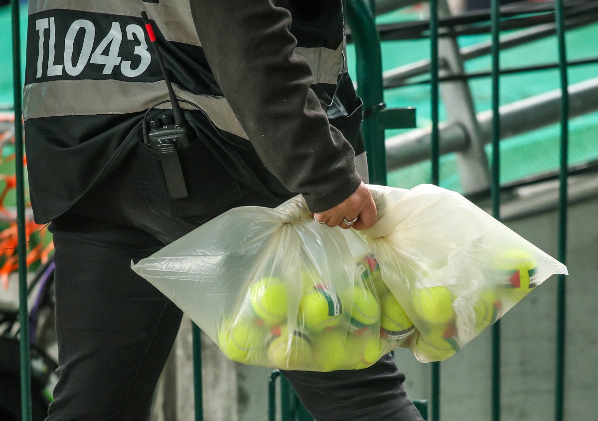 An official collects tennis thrown onto the pitch during the UEFA Nations League, League B - Group 3, football match between Republic of Ireland and Austria