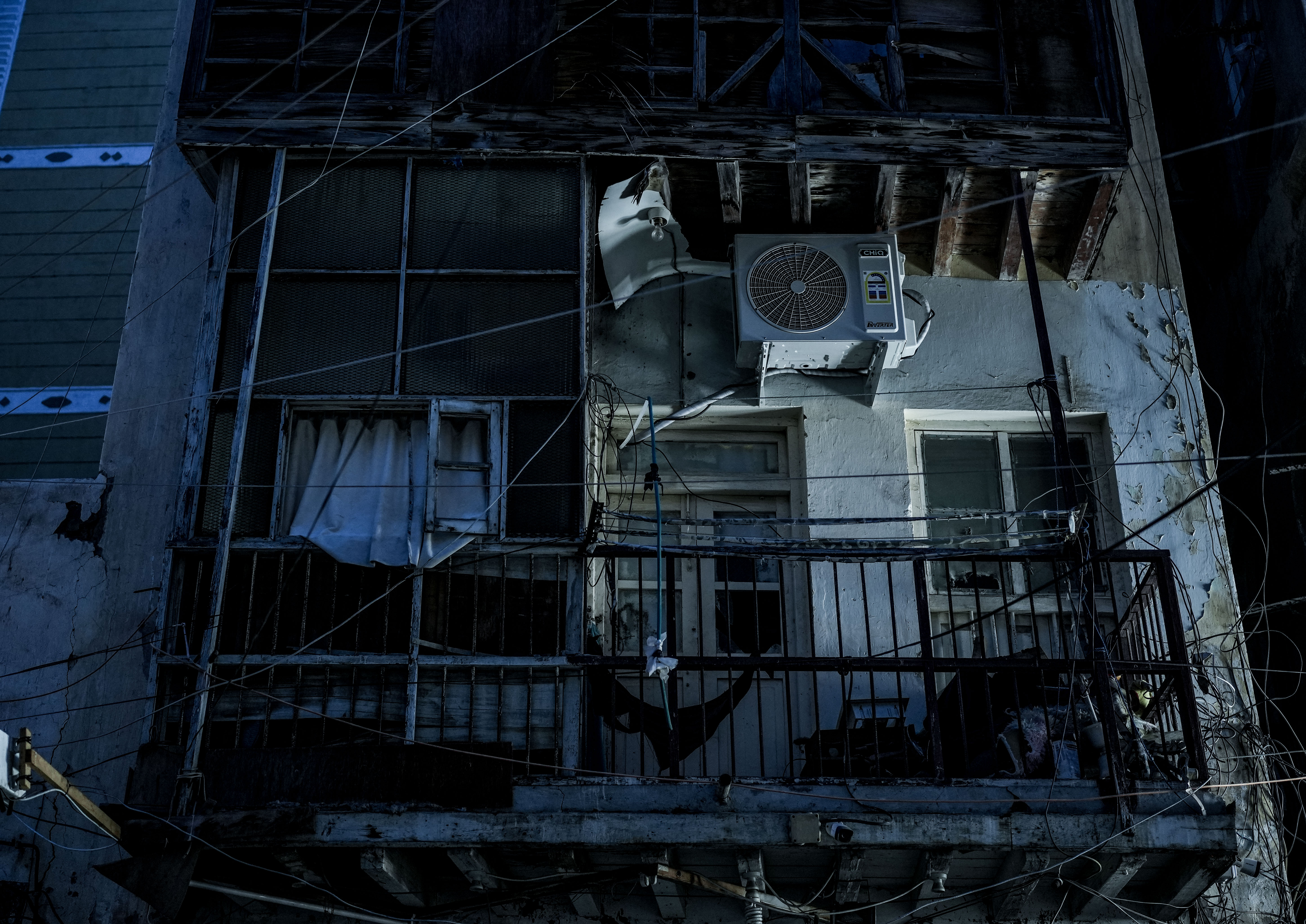 An air-conditioning unit hangs outside a residential building in Aden. During the summer months, high temperatures and humidity make prolonged electricity cuts especially difficult inside homes.