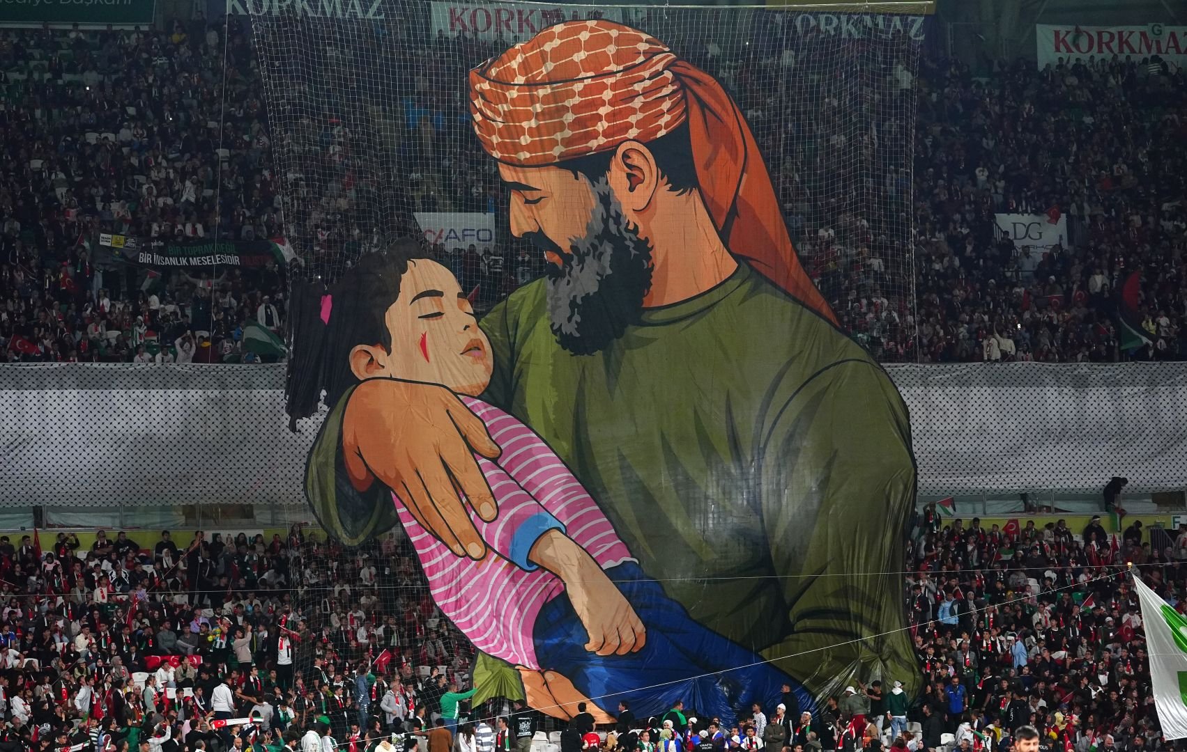 Fans open a choreographed sequence featuring Palestinian grandfather Khaled Nabhan, who is holding his granddaughter Rim, who had lost her life in the attacks on Gaza, in his arms and calling her "the soul of my soul" before a friendly match between Konyaspor and the Palestine National Football Team as part of Palestine Day events at Konya Metropolitan Municipality Stadium in Konya, Turkiye on September 30, 2026. [Evrim Aydın - Anadolu Agency]